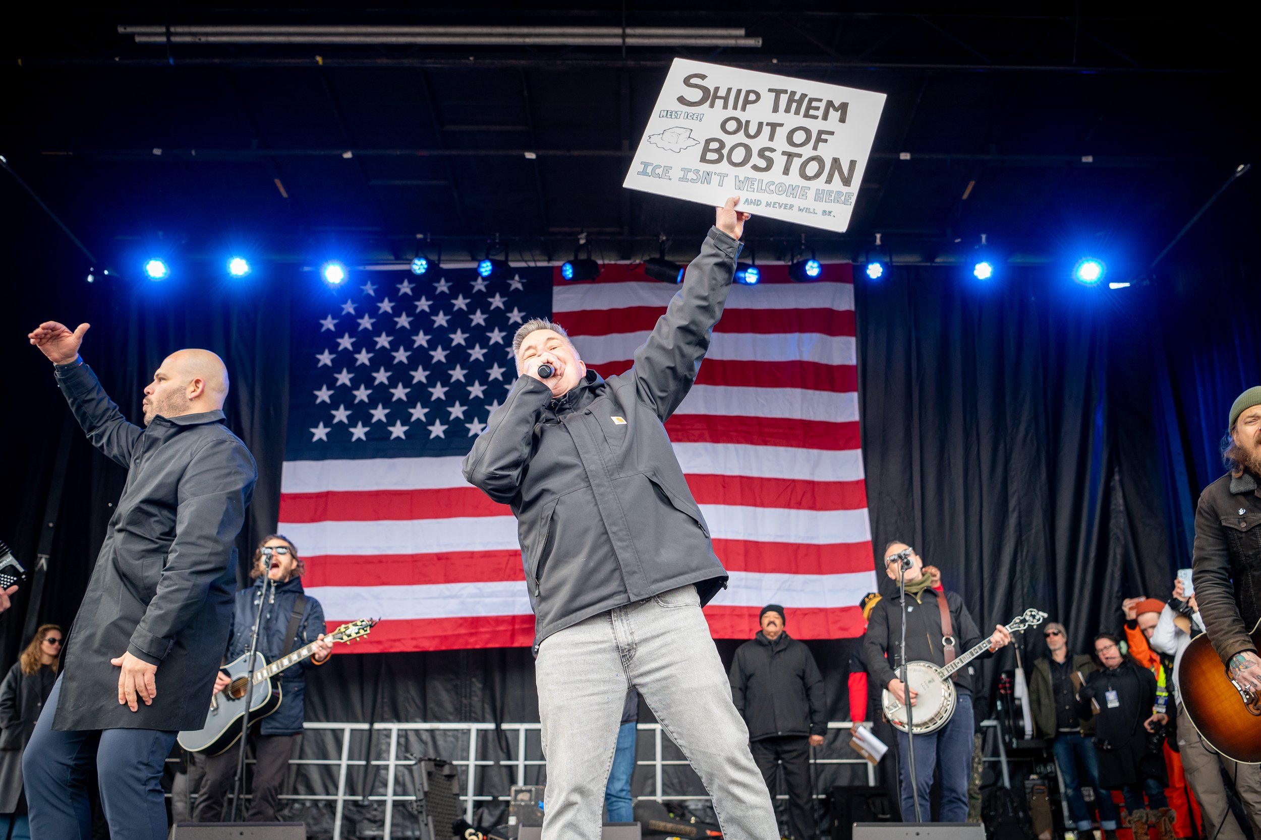Lead singer of Dropkick Murphys holding a sign that says "Ship Them Out Of Boston" while performing at No Kings III in Boston by Mass 50501.