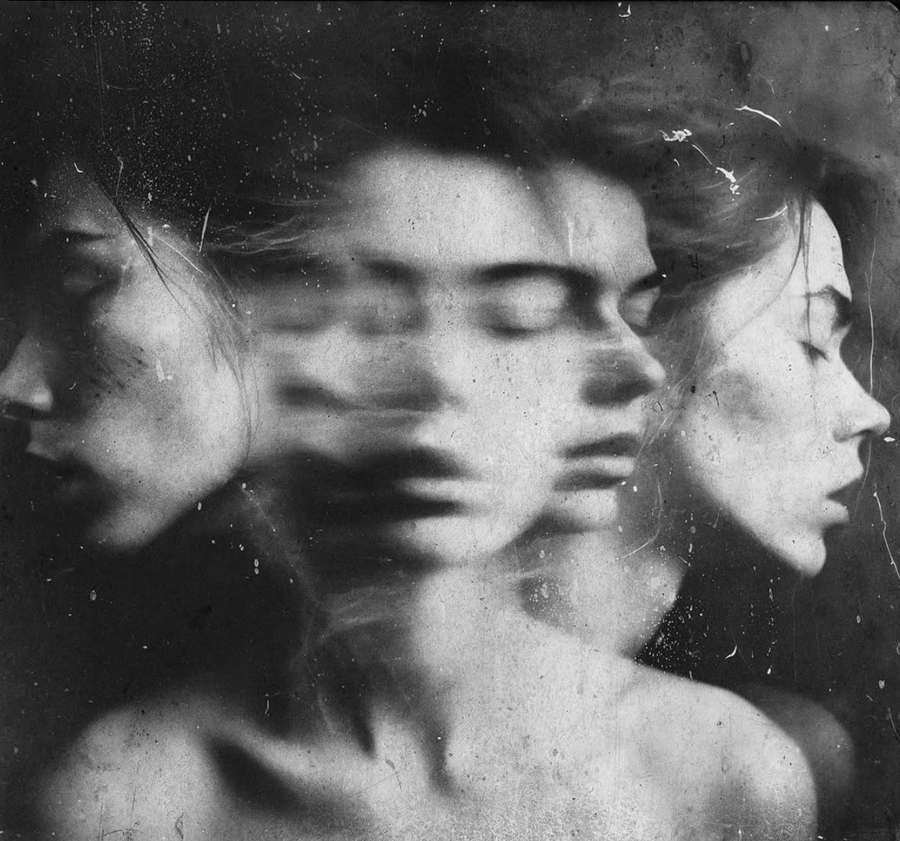 Black and white monochrome photograph of a woman with closed eyes, surrounded by blurred overlapping faces, with a textured and distressed appearance. A creative interpretation of the Structural Dissociation Model.