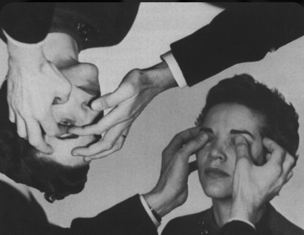 Black and white photograph of a woman having her eyes and face touched by multiple hands, with an upside-down reflection of the scene above. A creative interpretation of attachment theory.