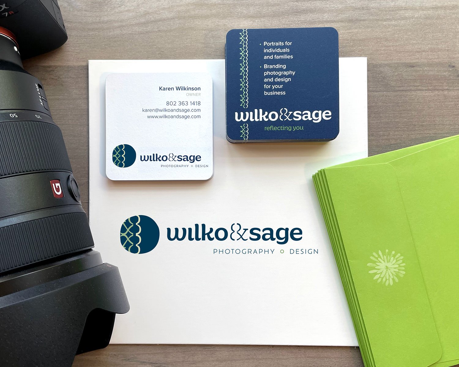 Business cards showing the front and back of the designs plus a camera and envelopes