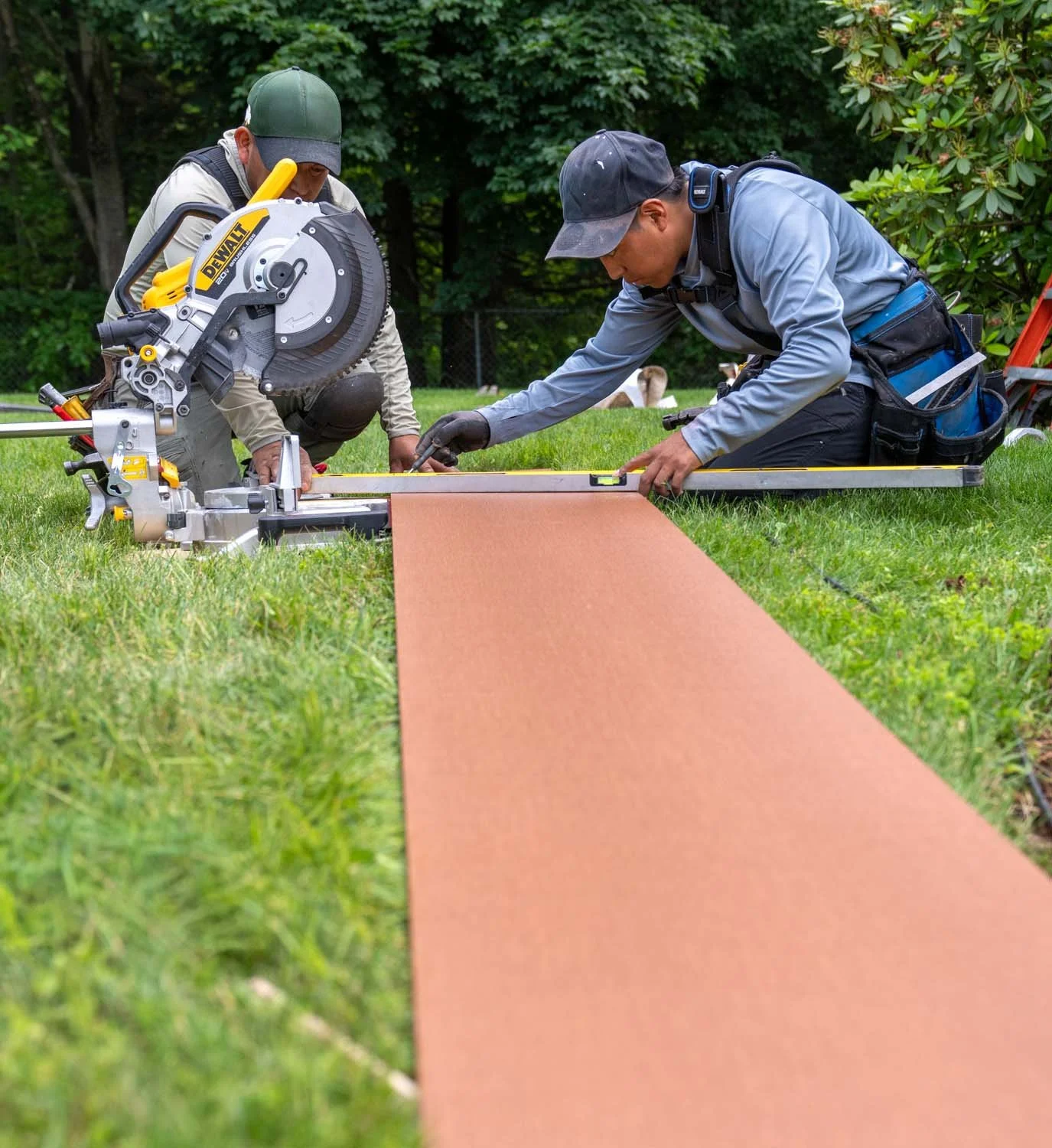 two workers preparing to saw a large board for housing exterior