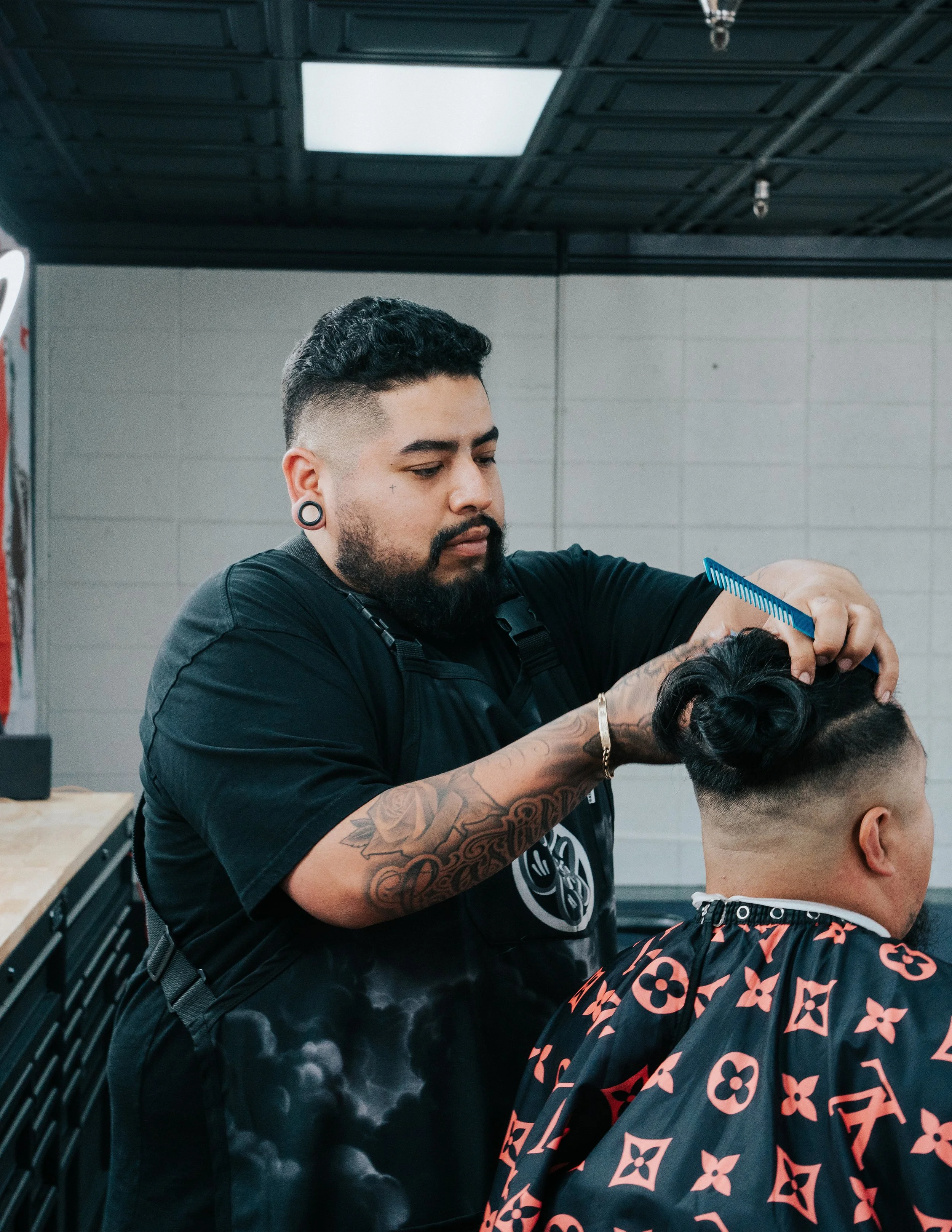 Person crouching beside a custom motorcycle in a garage, with the sign "KULTURED" on the wall behind.