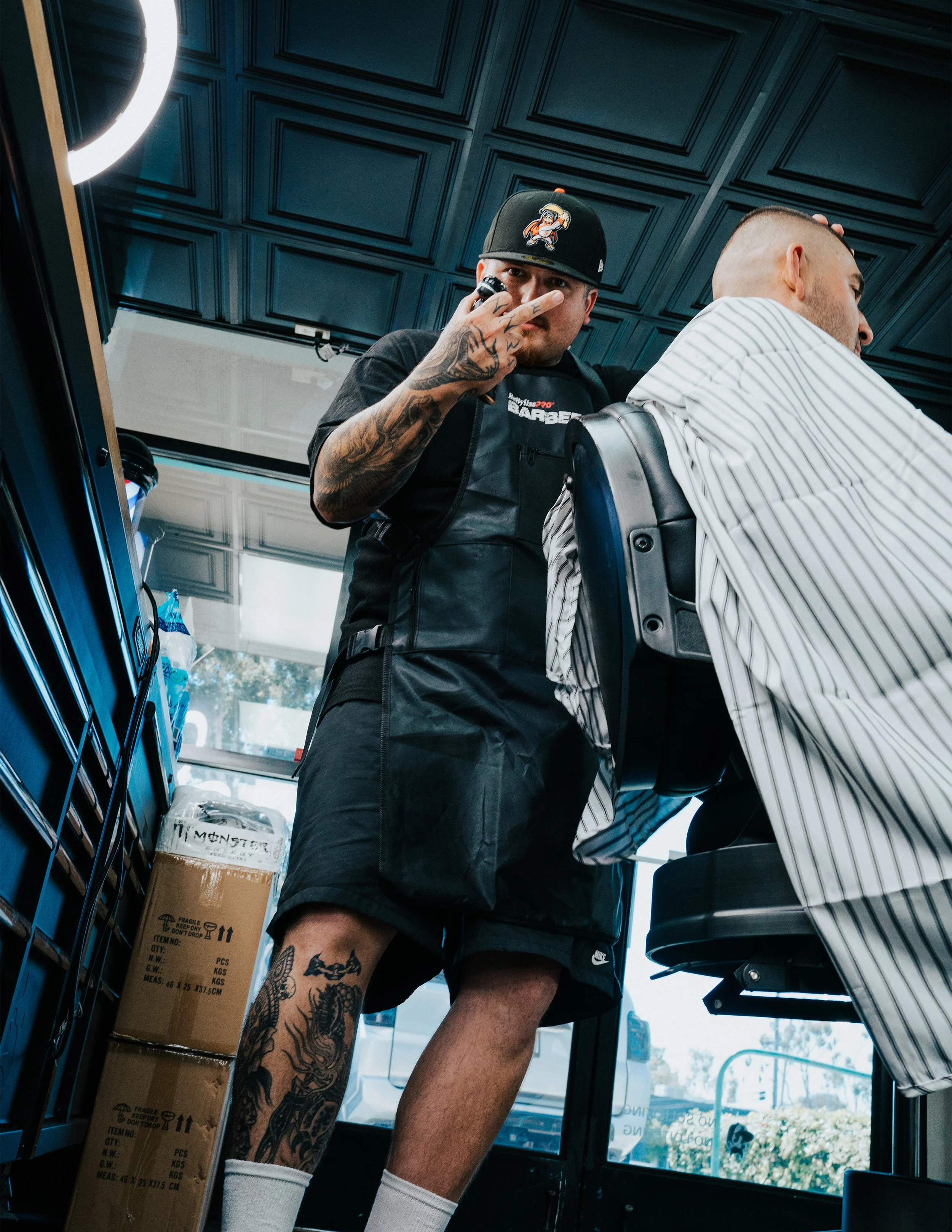 Barber drying client's hair in barbershop.