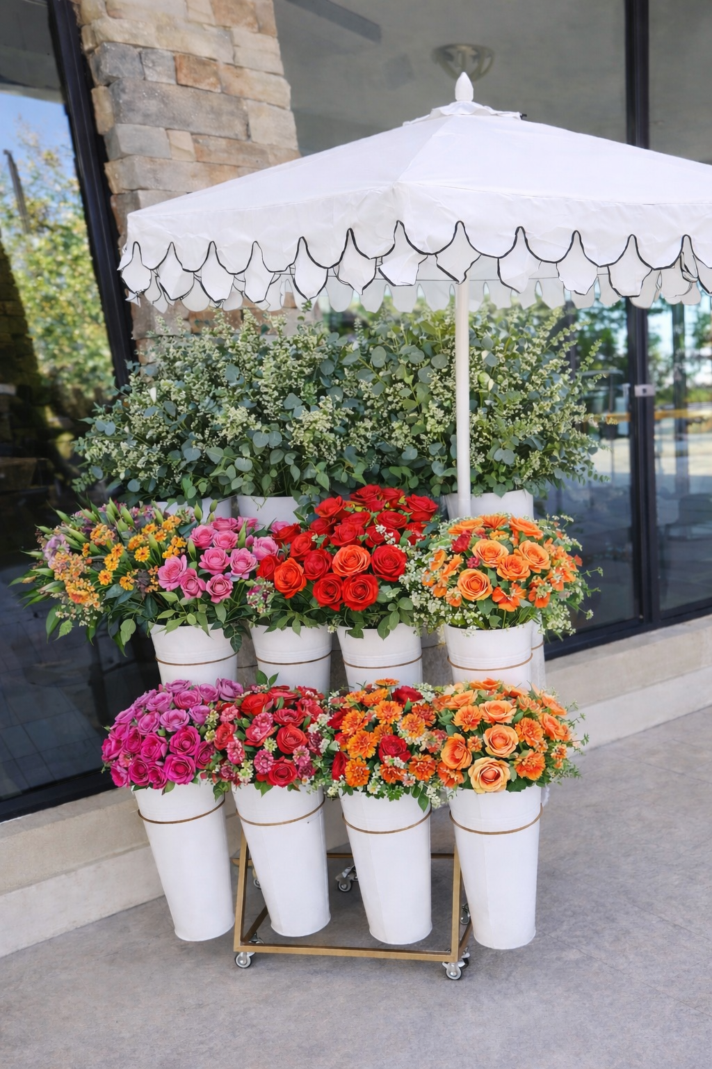 Bloom Bar flower cart with fresh roses, carnations, daisies, and greenery arranged in white buckets under a decorative umbrella, perfect for weddings, bridal showers, and events.