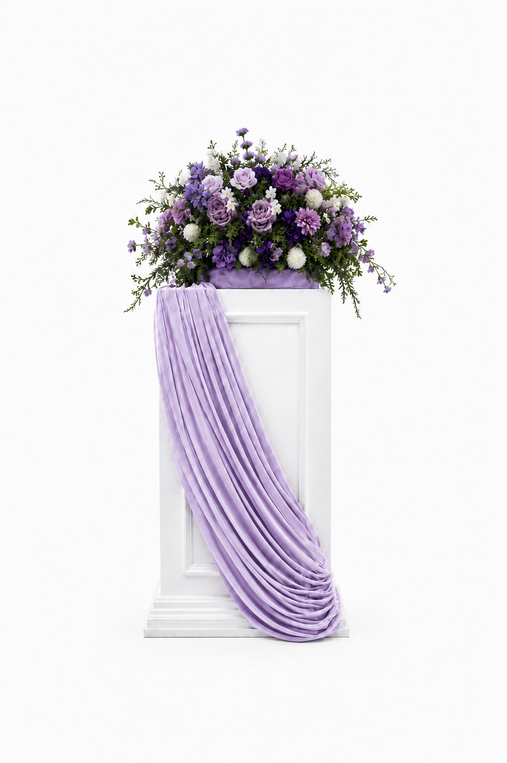 Purple floral arrangement with lavender roses, purple blossoms, and greenery displayed with lavender draping.