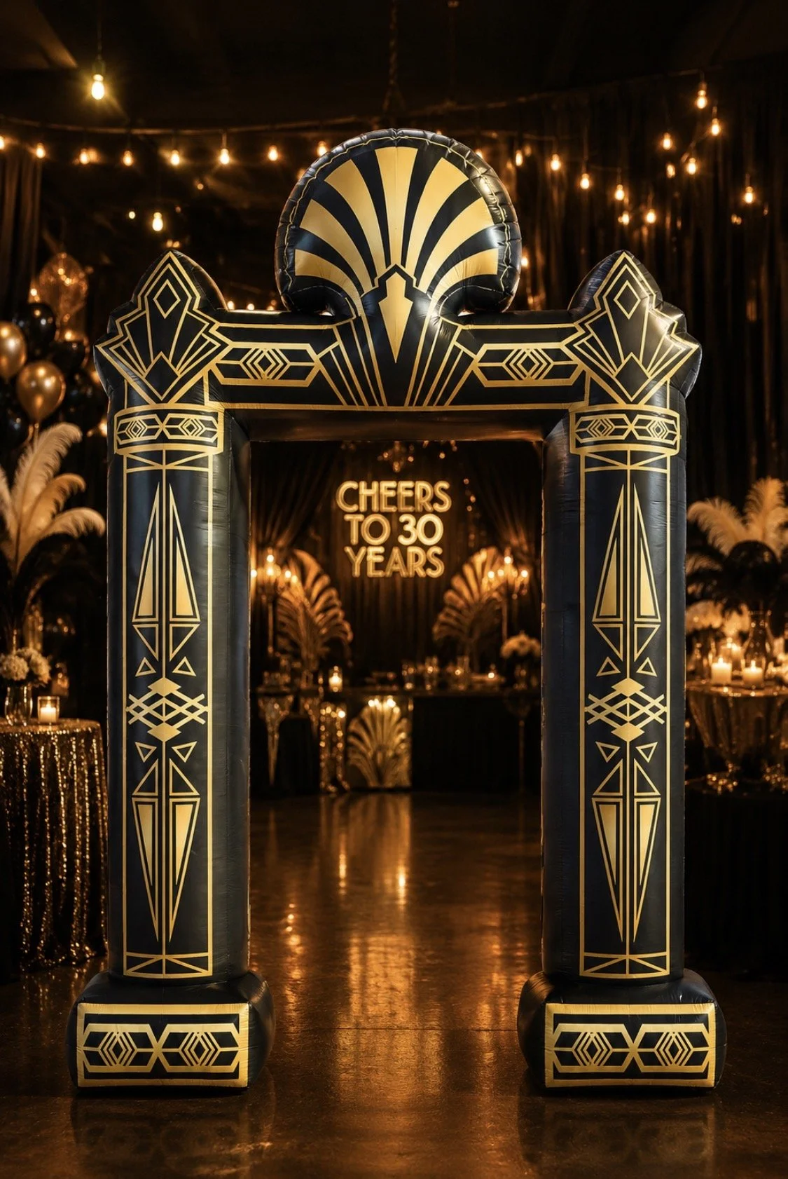 Black and gold Art Deco inflatable arch displayed at the entrance of a glamorous Roaring Twenties-themed birthday party with elegant gold décor, feather accents, warm string lights, and a glowing “Cheers to 30 Years” neon sign in the background.