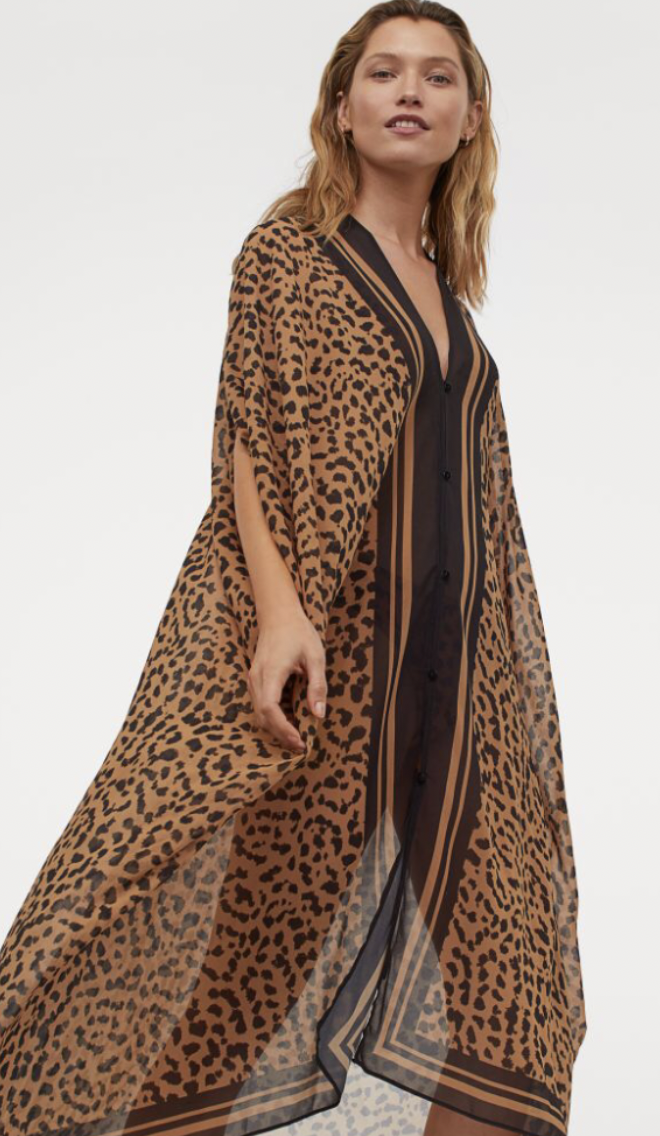Woman modeling a sheer, leopard print cover-up with black and brown vertical stripes over a black swimsuit.