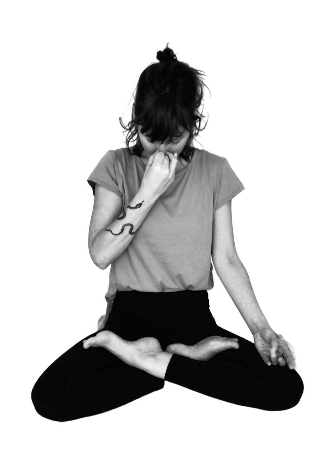 Junge Frau in Meditationsposition mit Lotus-Sitz, die Hand an die Nase hält, auf einem schwarzen Hintergrund