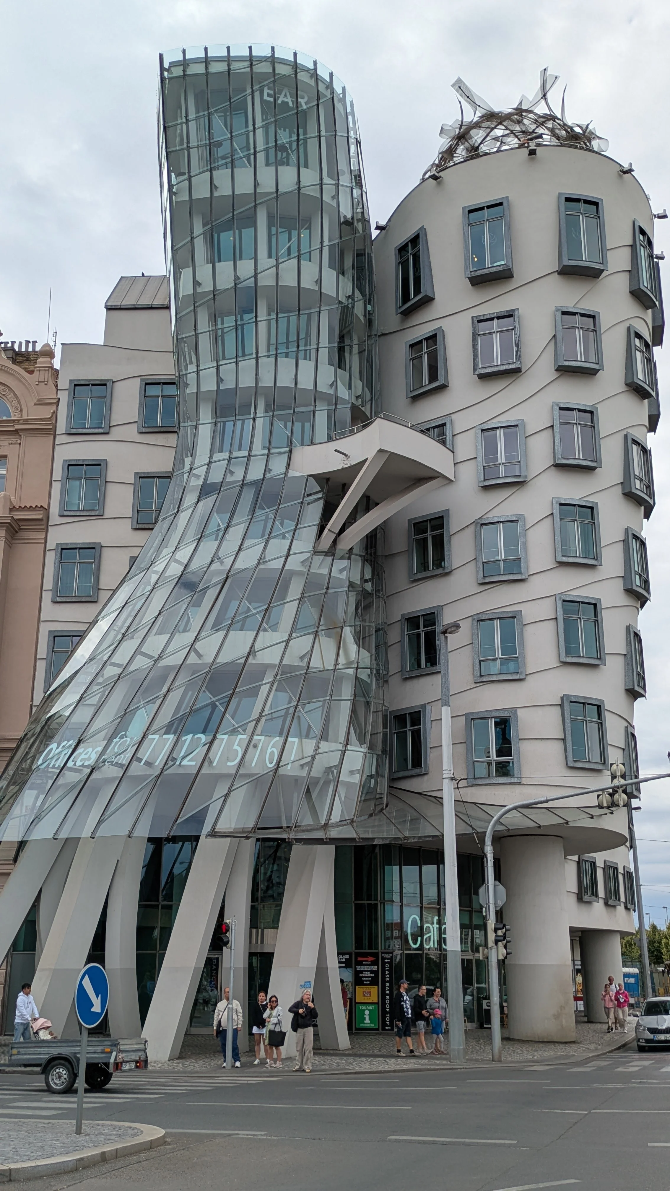 two narrow, 8-story buildings, side by side. One made of glass narrows in the center like a woman's waistline.