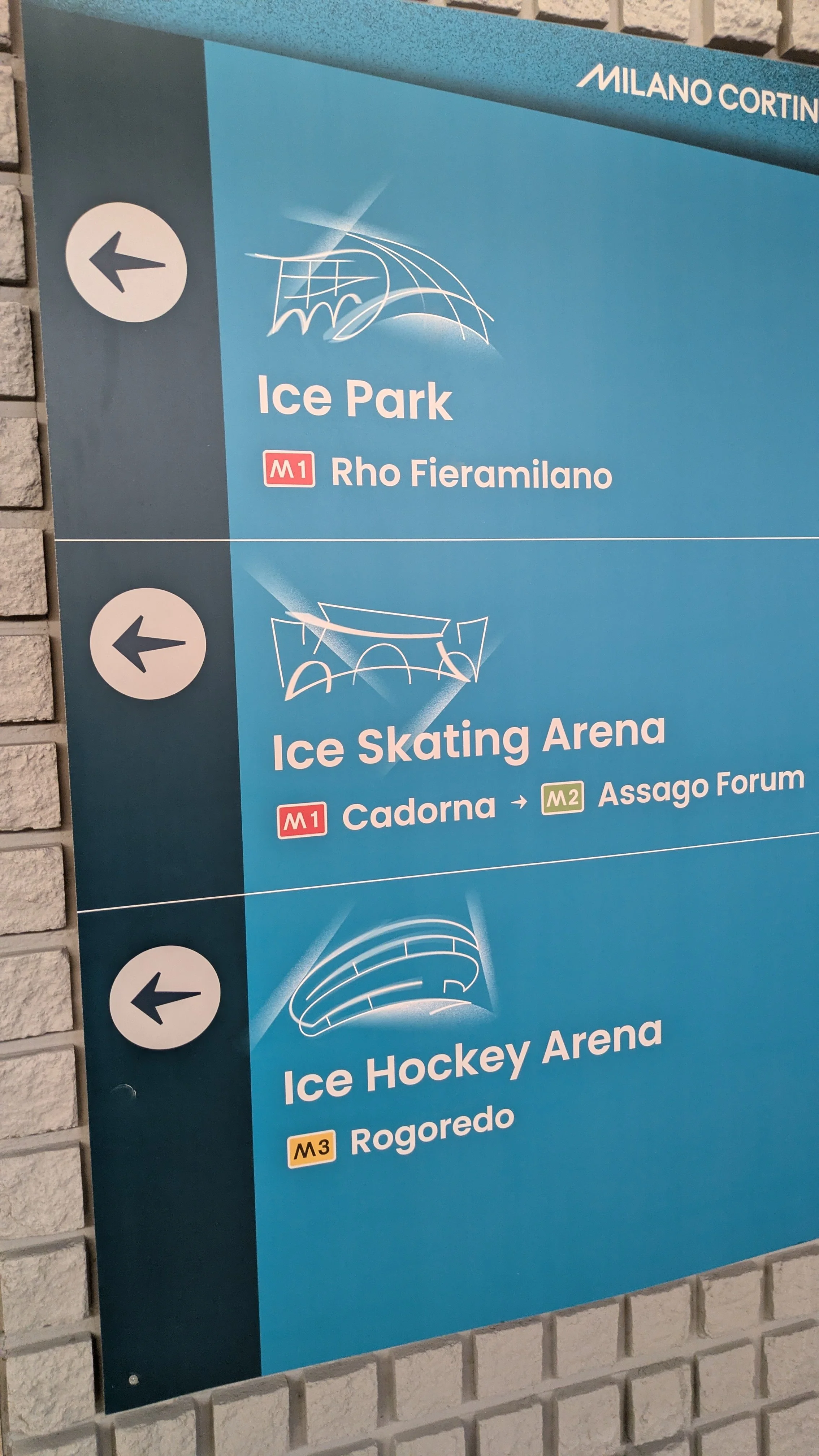 Blue signage pointing to ice skating and  hockey arenas.