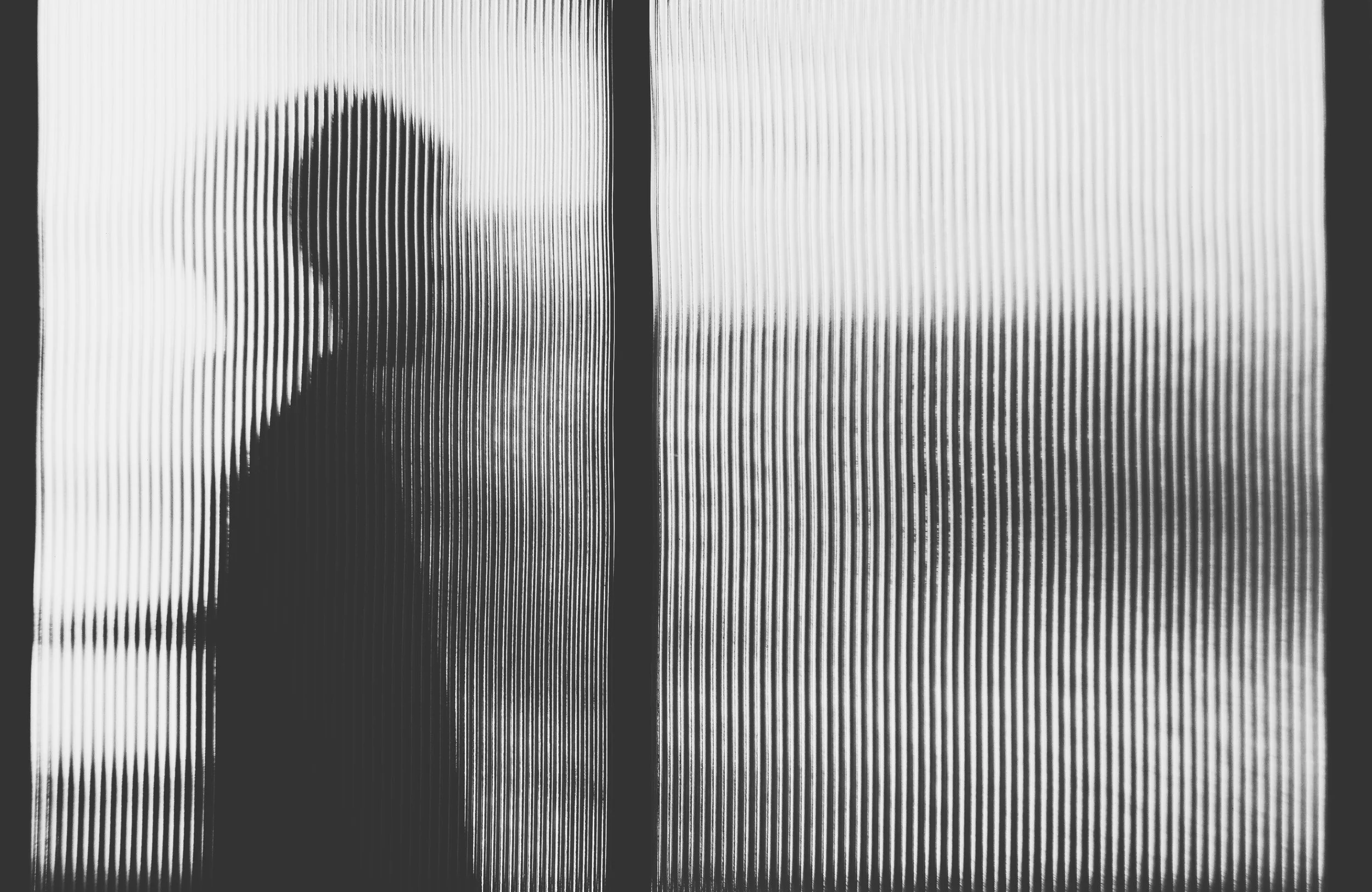 Silhouette of a person behind frosted glass with vertical lines pattern