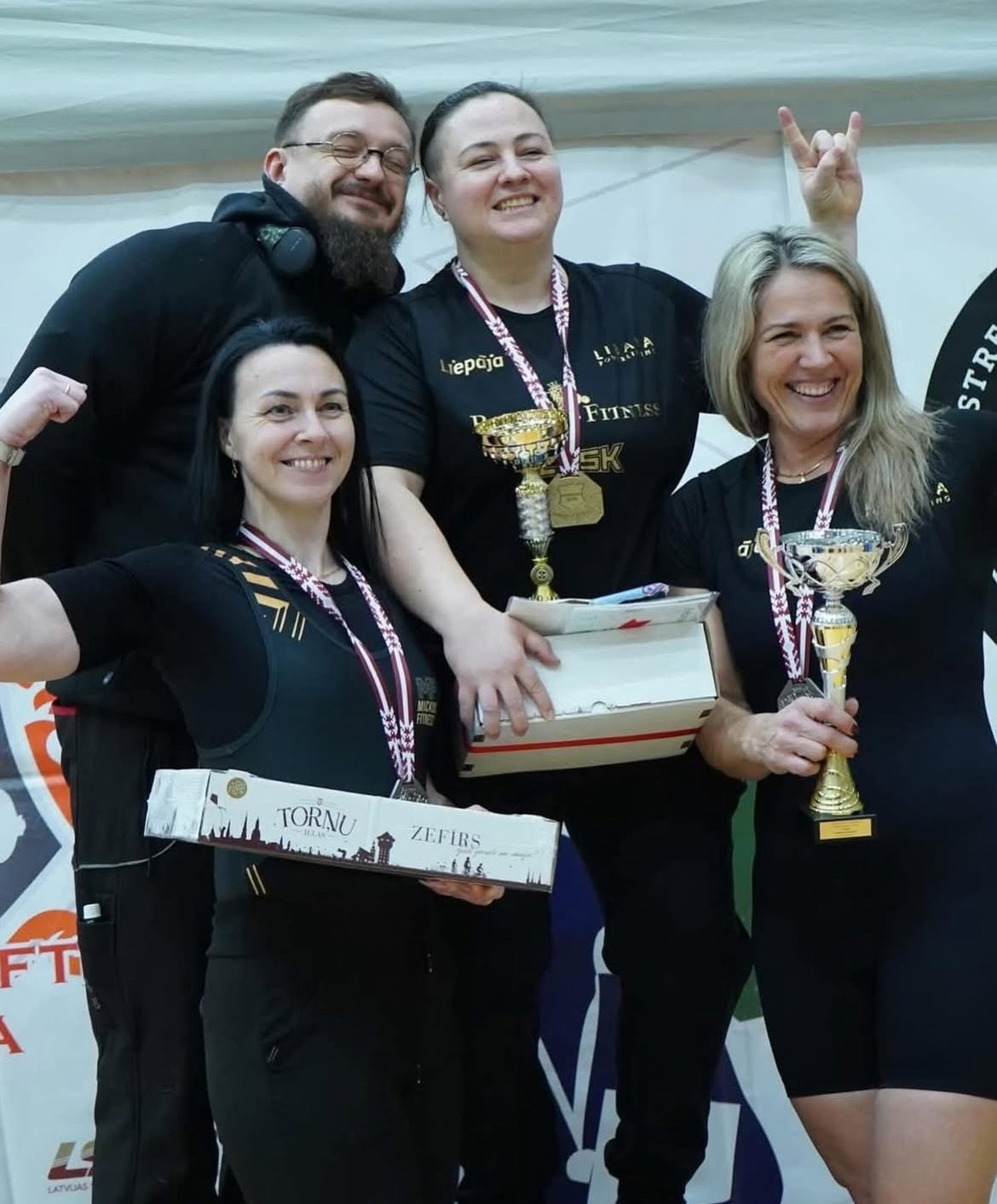 Group of athletes celebrating with trophies and medals
