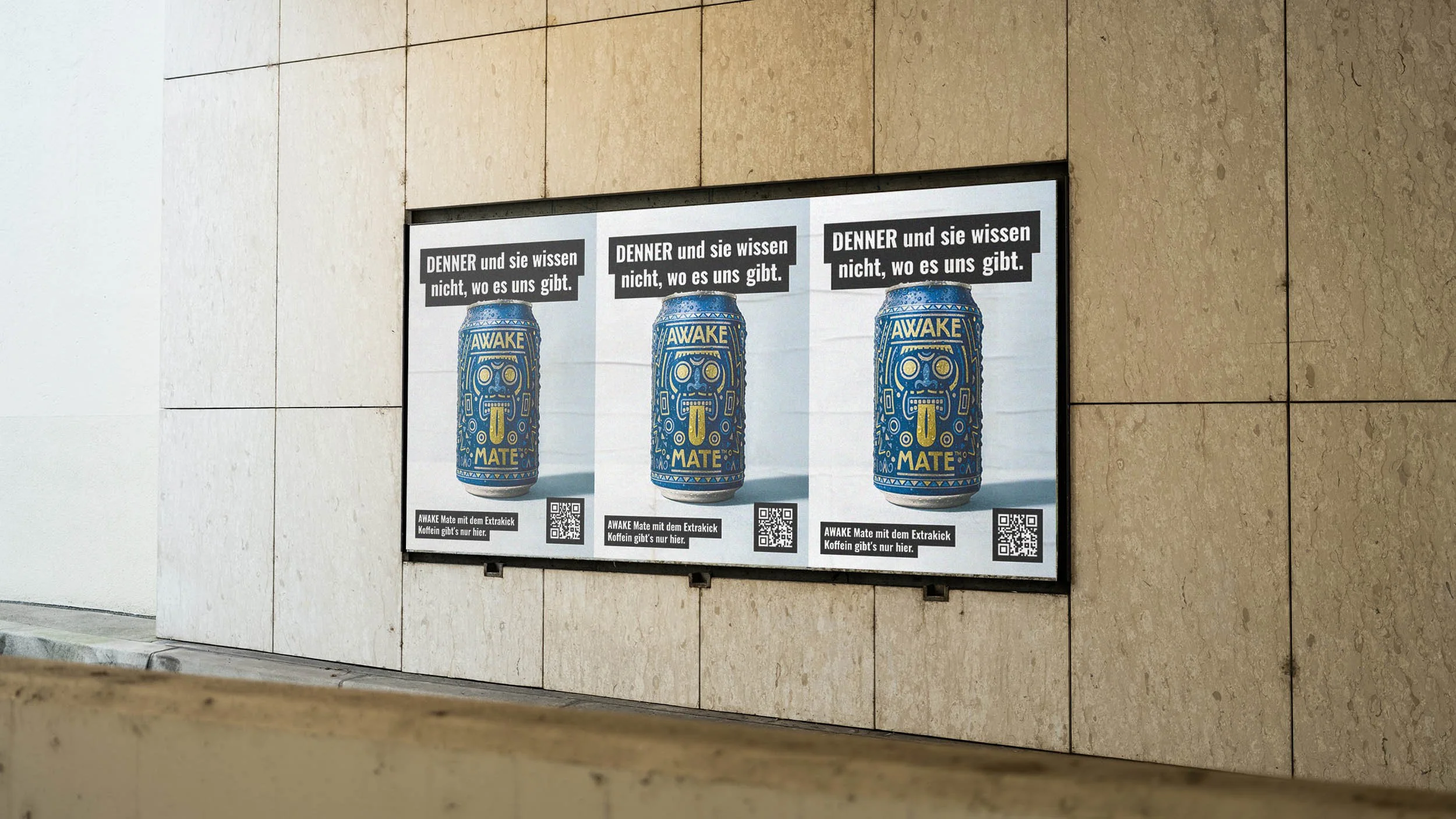 Drei gleiche Plakate an einer Wand, jeweils mit einer blauen Getränkedose mit Bumerang-Motiv und der Aufschrift »AWAKE MATE«. Über den Dosen befindet sich der Text »DENNER und sie wissen nicht, wo es uns gibt.«, und unten ein QR-Code und ein Hinweistext.
