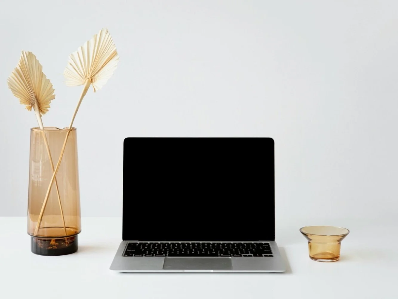 squarespace web designer mac computer on a desk with a vase with dried flower