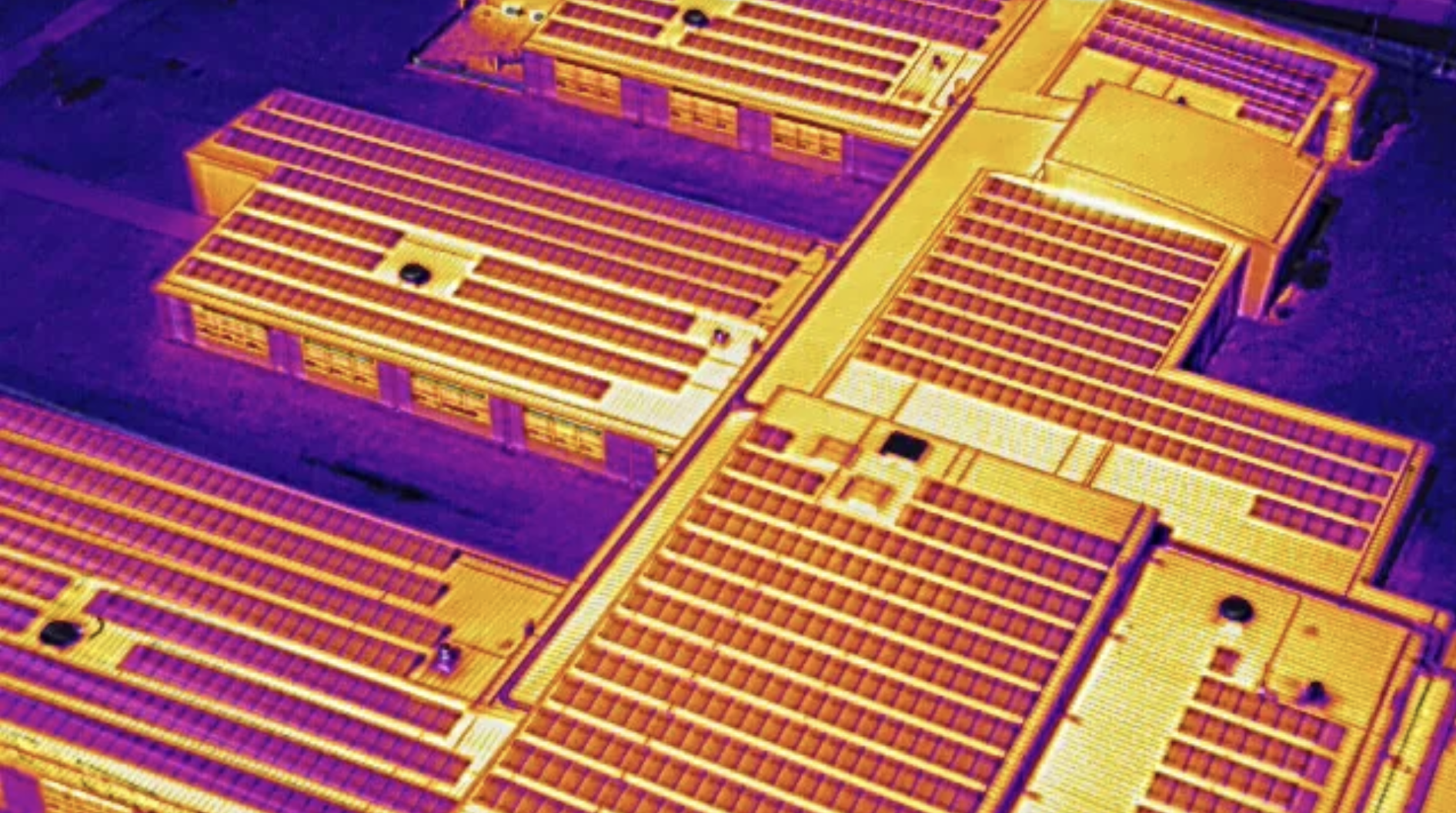Thermal image of industrial buildings with solar panels on roofs to identify anomalies and defects for insurance and warranty claims performed by a drone for aerial thermal inspections with IR and RGG imaging by a certified thermographer and part 107