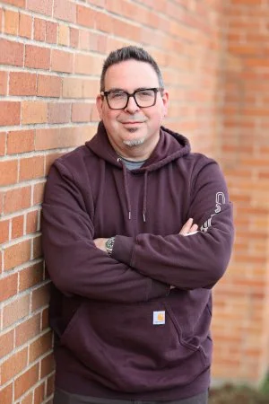 Simon standing by a wall