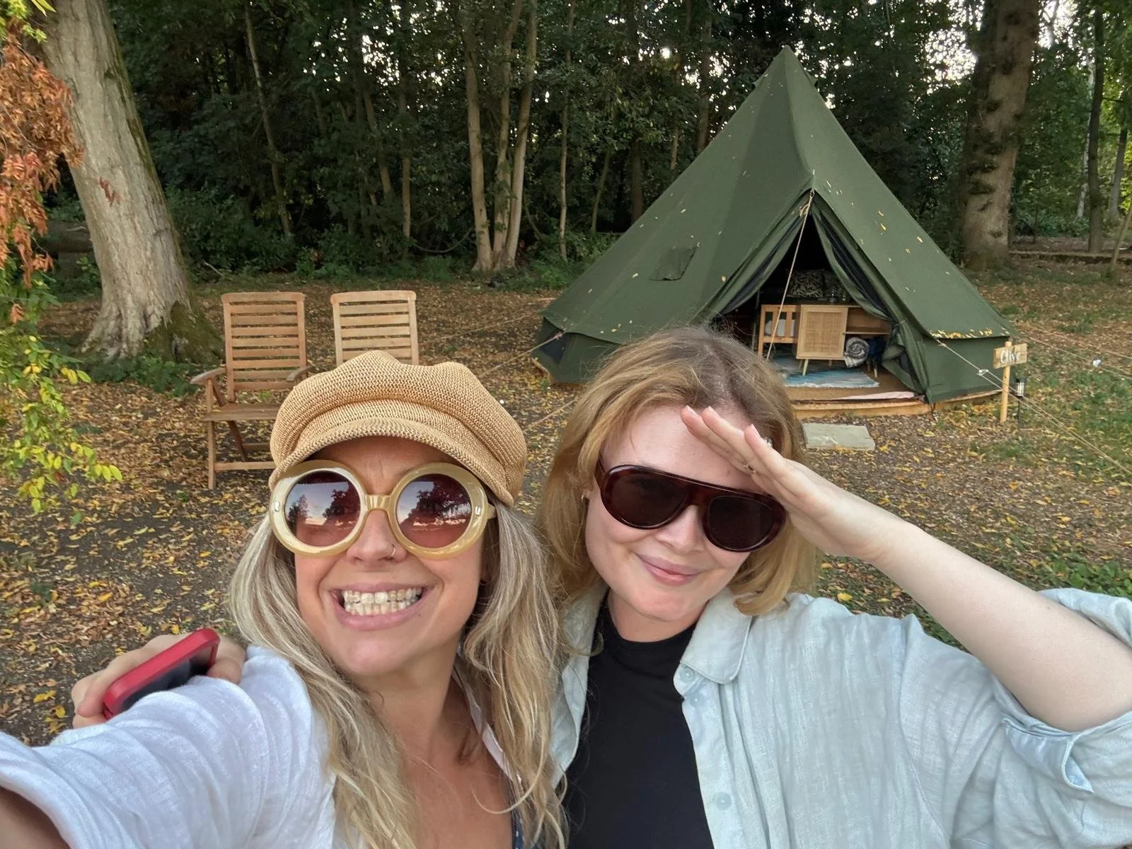 Guests taking selfie in front of woodland bell tent at The Grove