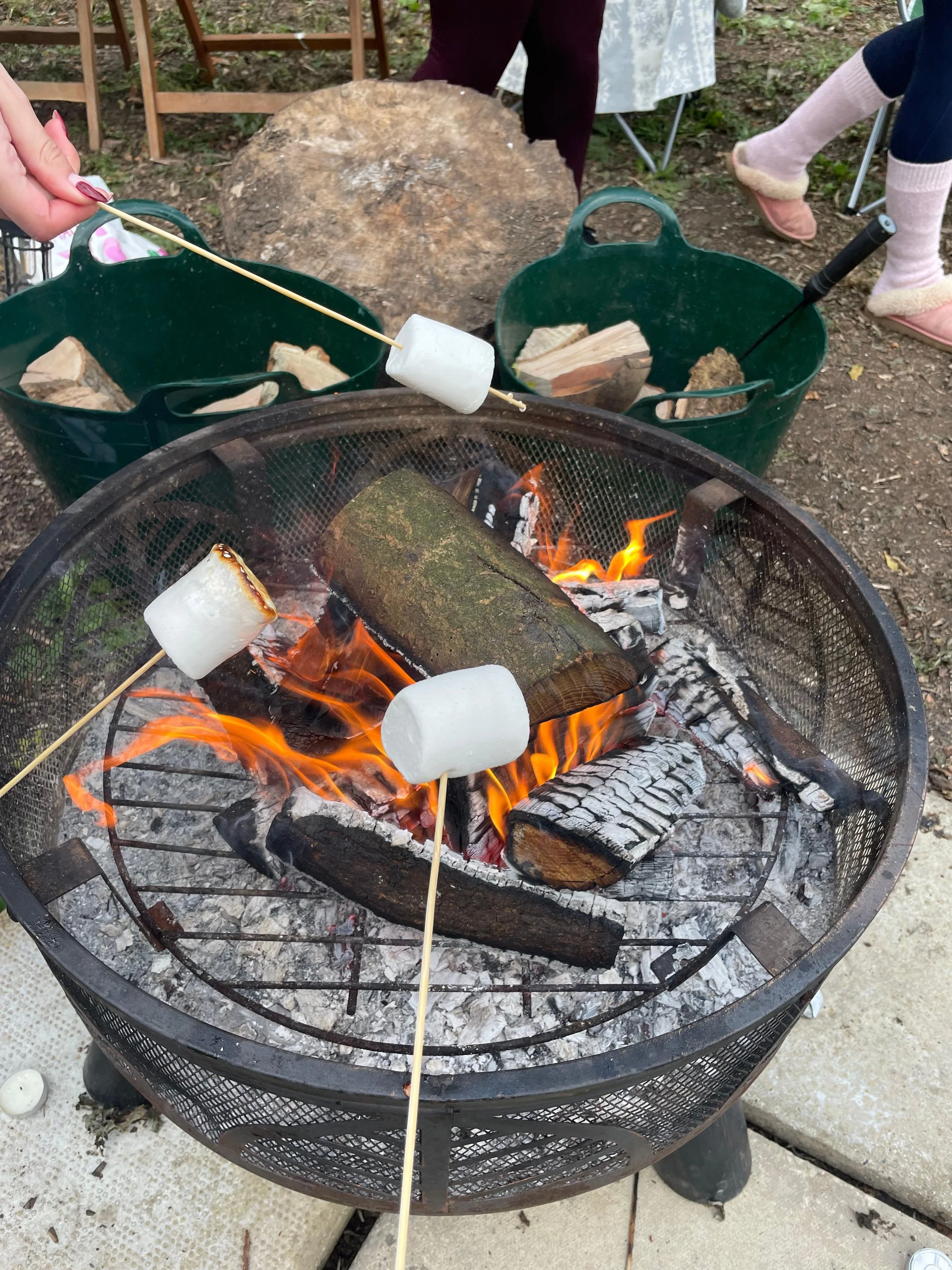 Toasting marshmallows over the fire pit at a group glamping event