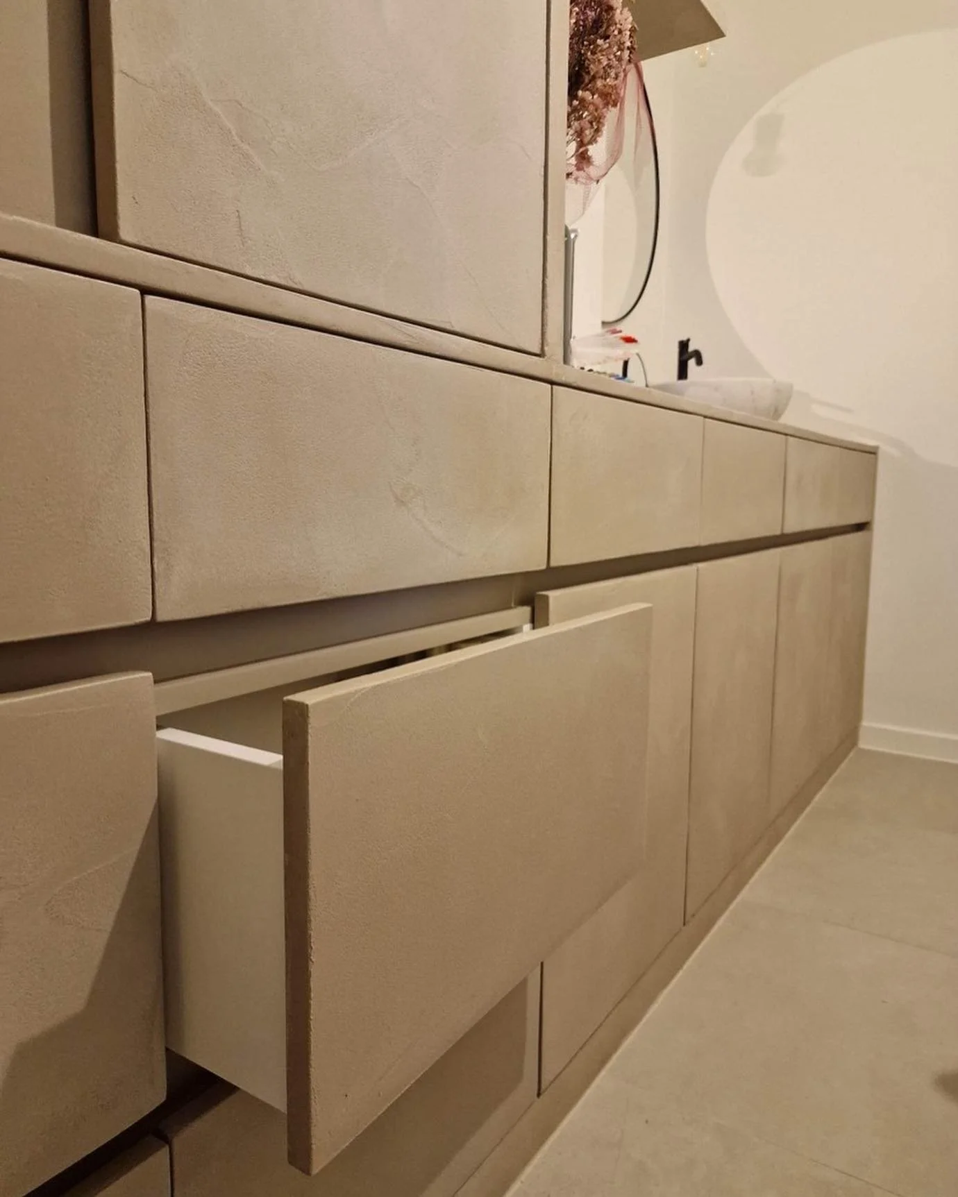 Op maat gemaakte schuiven in zacht bruin microcement afwerking voor schoonheidssalon