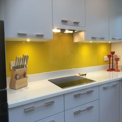 yellow bespoke glass splashback behind gas hob.JPG