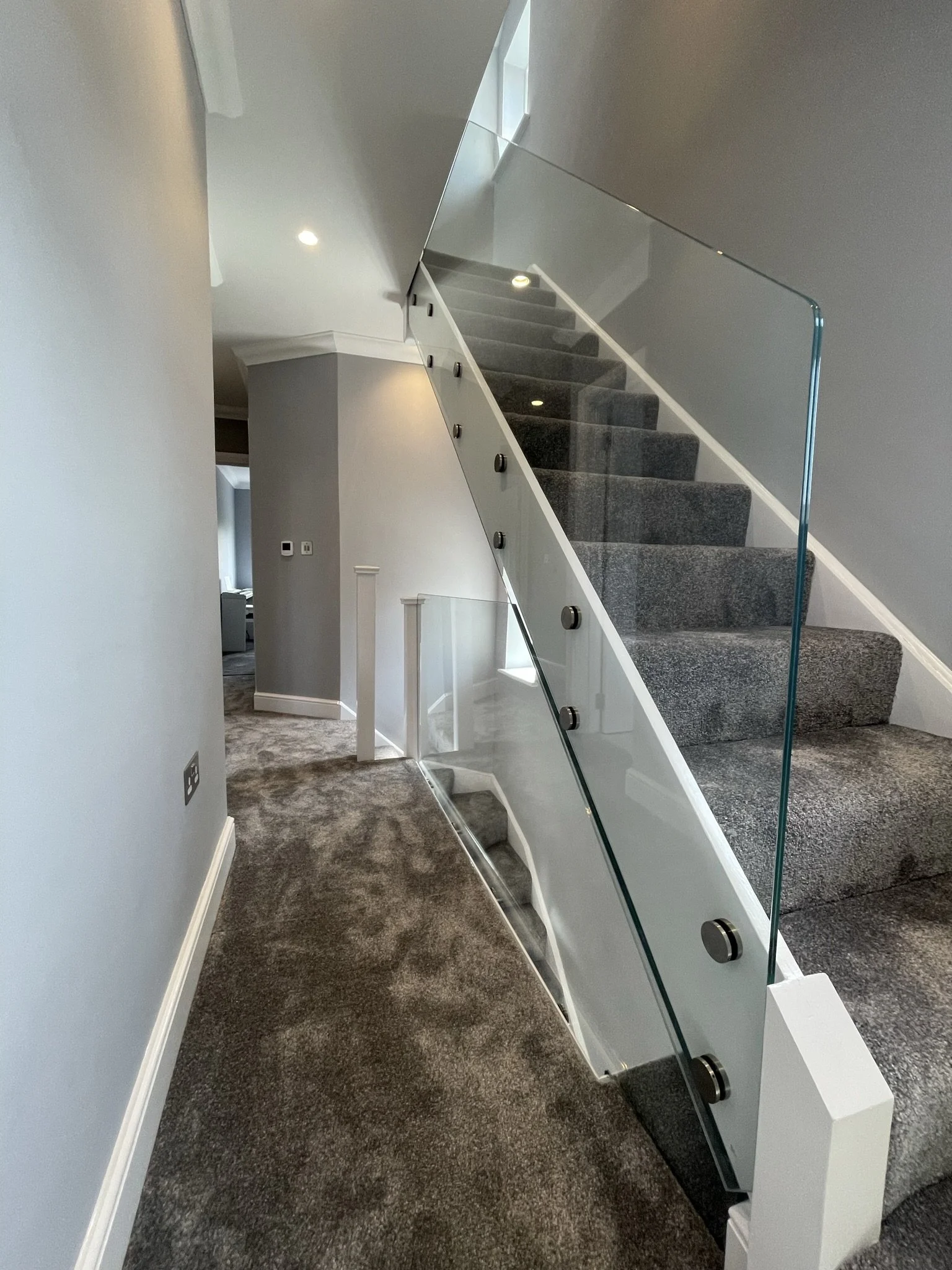 Toughened laminated glass balustrade with CNC-polished edges mounted on stainless steel standoffs