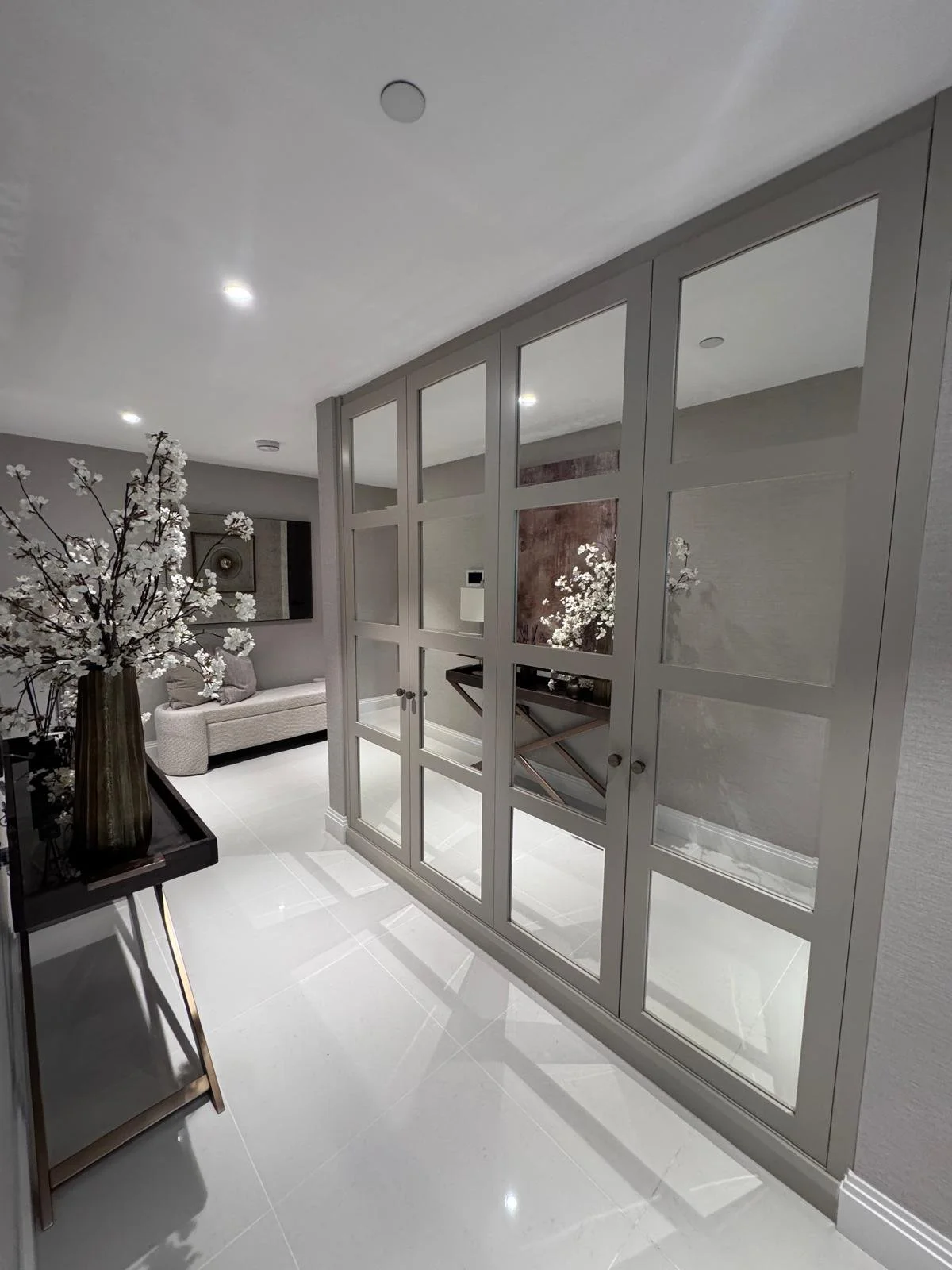 Mirrored cabinet doors installed within a fitted wardrobe creating practical storage with a reflective finish