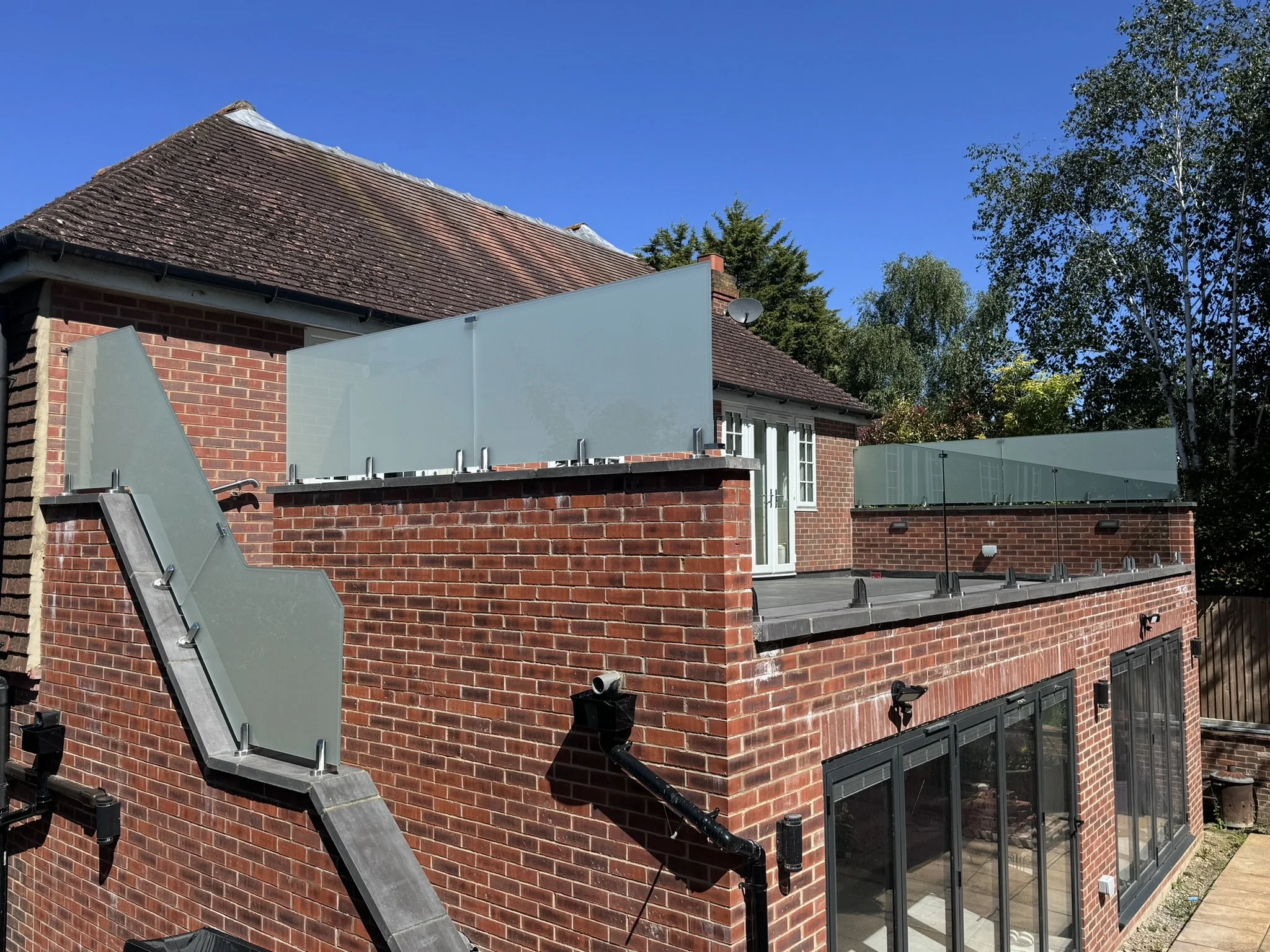 Satin finish toughened laminated glass privacy barrier panels fixed to structure for screening and fall protection