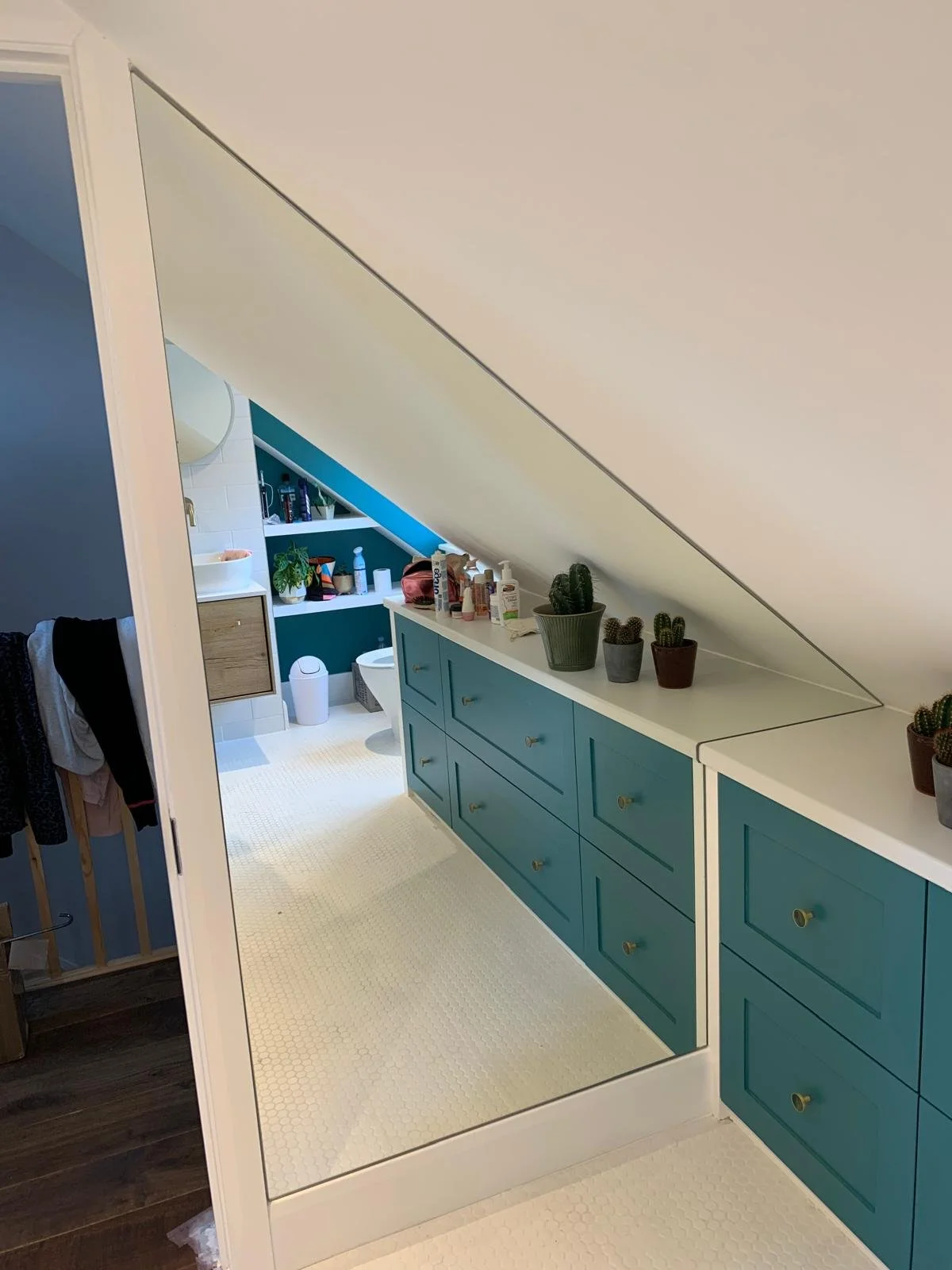 Custom shaped mirror cut to fit a feature wall and architectural angles in a contemporary interior installation.