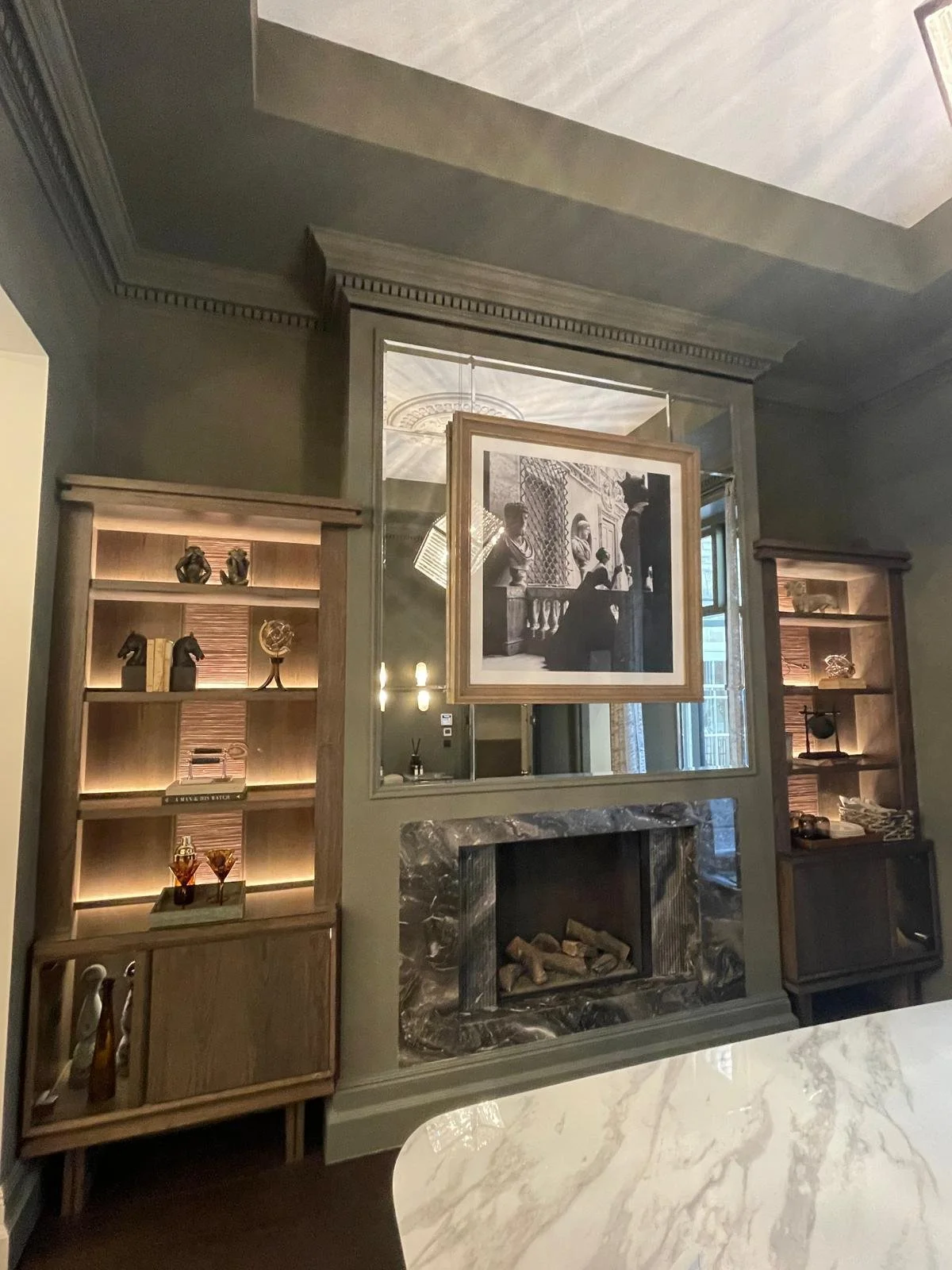 Large statement antique feature wall mirror installed in a modern living room to reflect light and complement contemporary interior design.