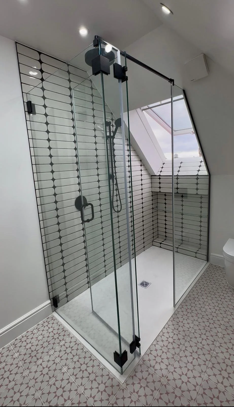 Bespoke frameless shower screen installation in New Malden using 10mm low-iron toughened glass with matte black fixings