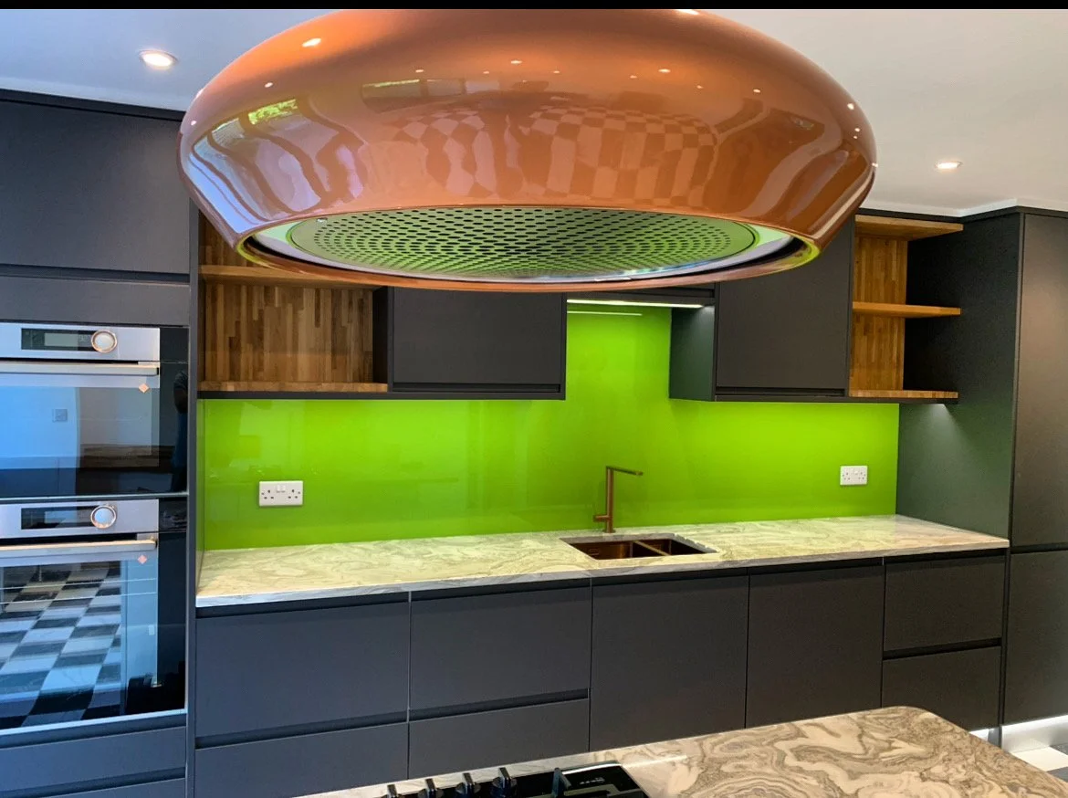 Green toughened glass splashback, back-painted for a sleek finish, installed in a kitchen in New Malden.