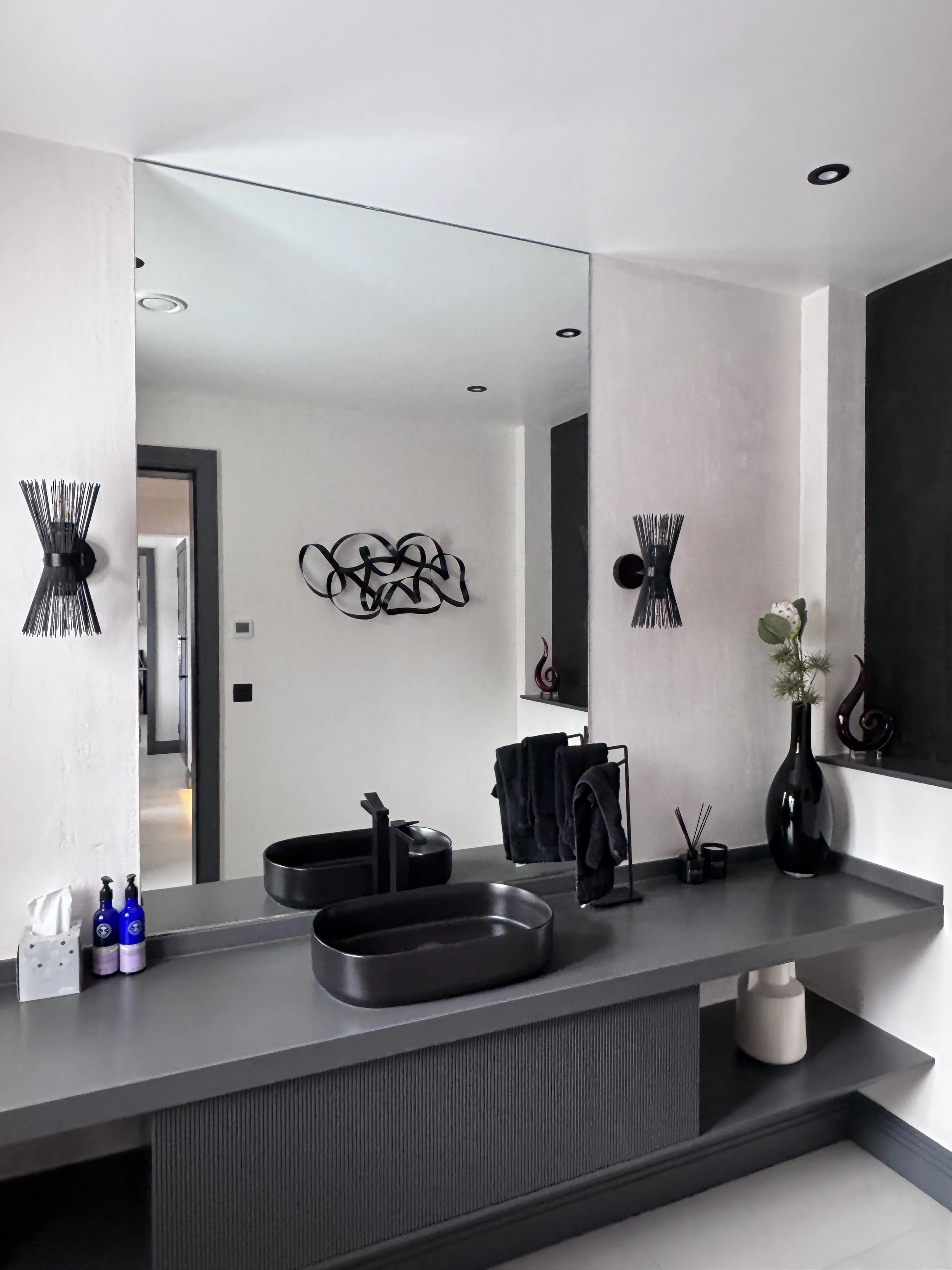 Bespoke bathroom mirror wall installed above a contemporary vanity basin with polished edges and precision fitting in a modern Surrey bathroom.