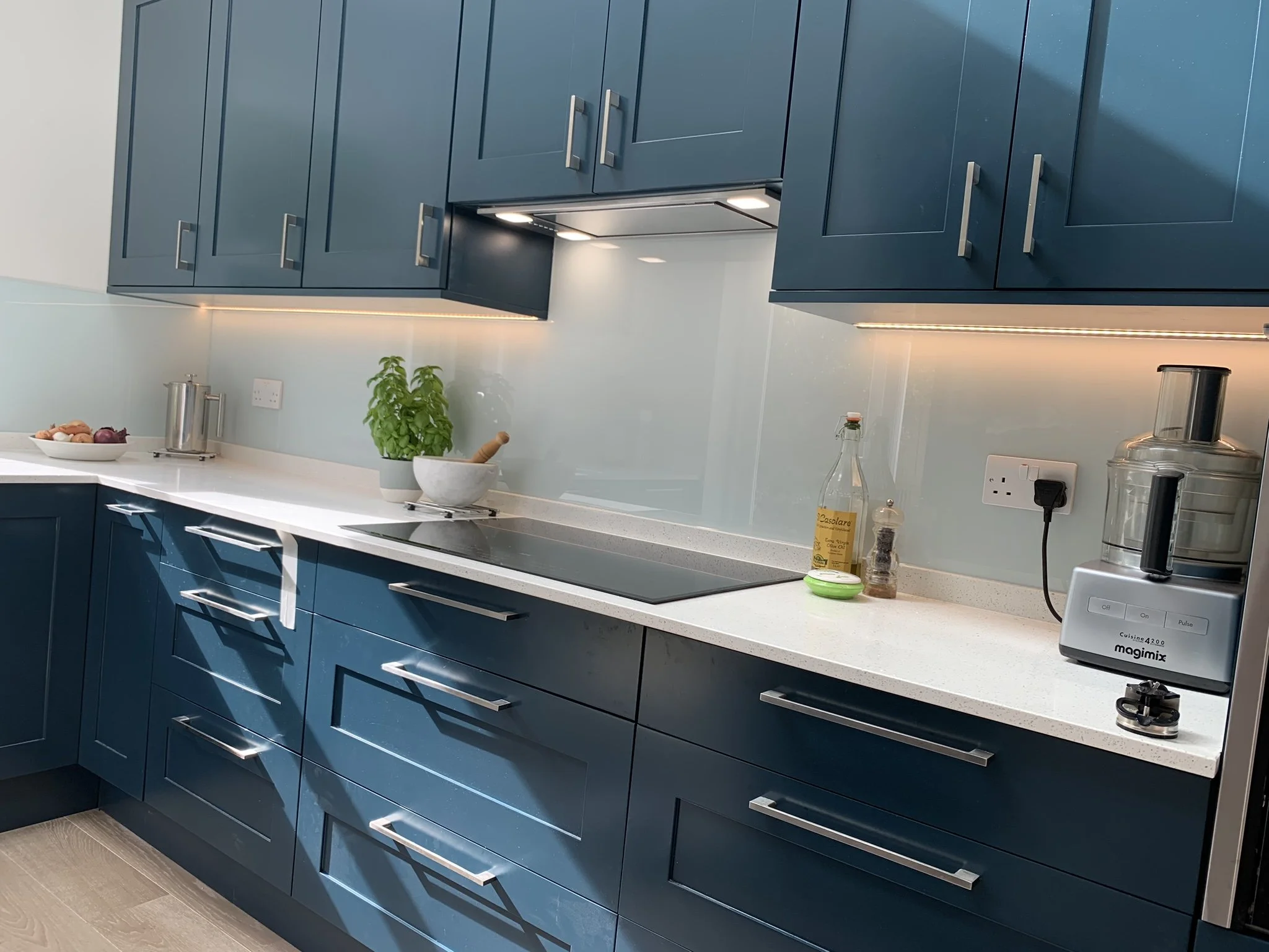 Made to measure glass splashback in Kingston KT1 kitchen with seamless finish and white quartz worktops