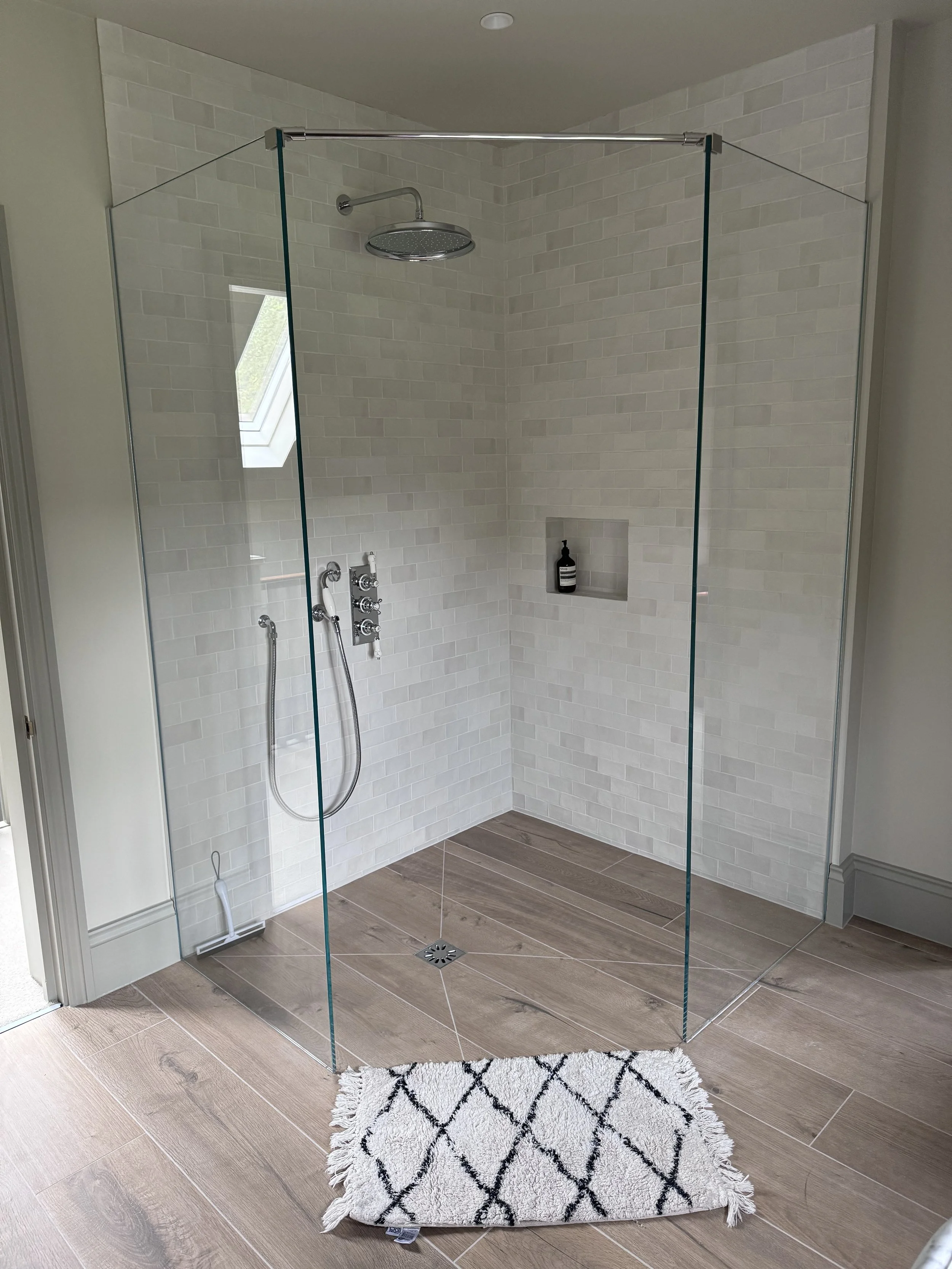 Walk-in toughened glass shower screens with central opening, cut to size and edge polished for barrier-free access