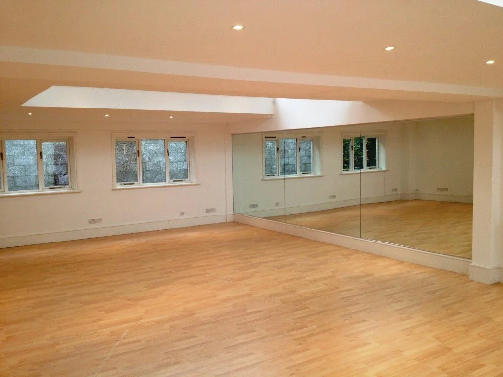 Full wall dance studio mirrors installed in a professional fitness studio with polished edge safety mirrors fitted across an entire mirrored wall.