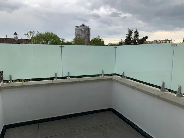 Satin obscure toughened laminated glass balustrade fixed to a pelmet wall with stainless steel clamps