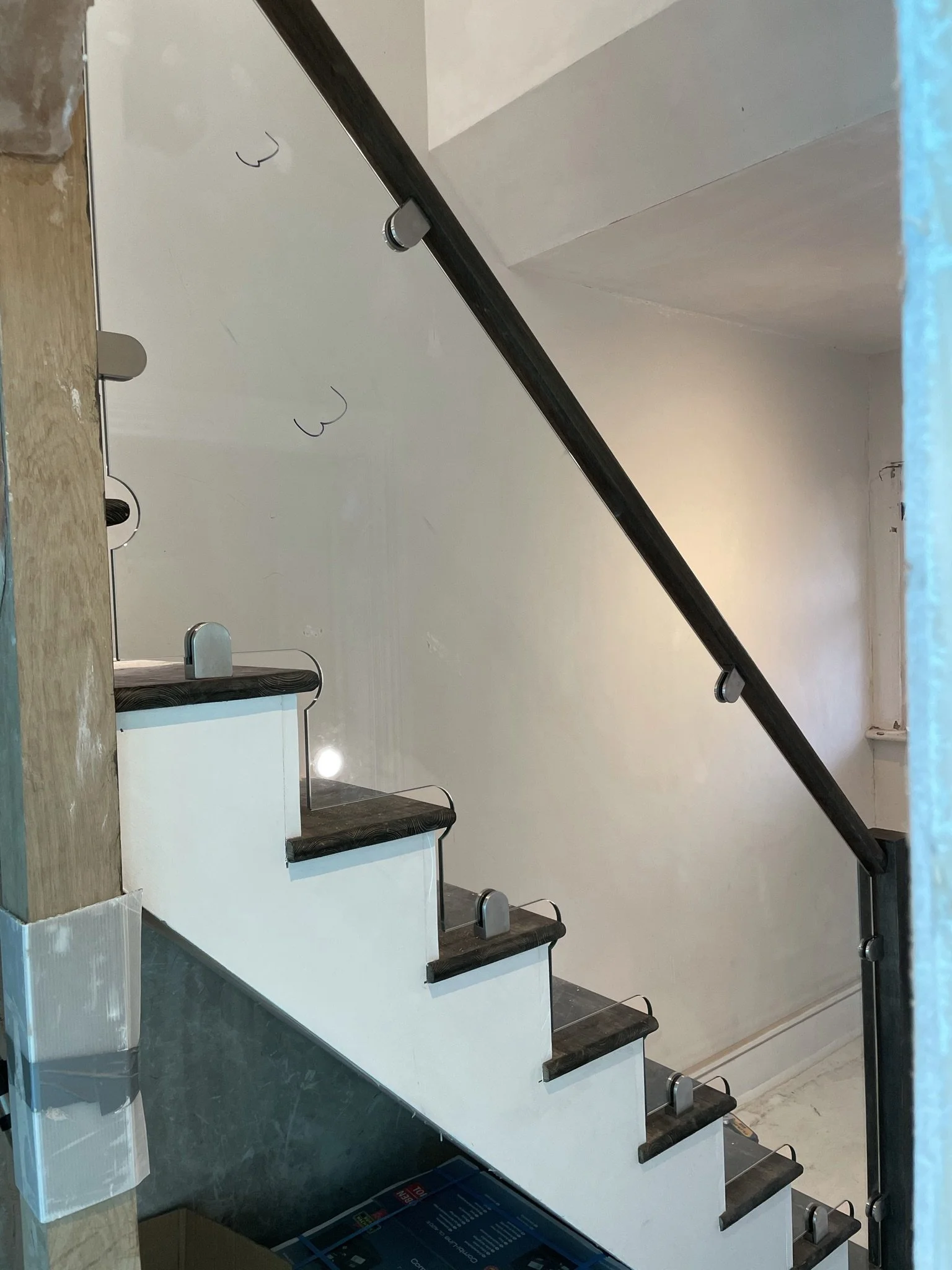Toughened glass balustrade panels CNC-shaped and polished to follow staircase profile with precision fit