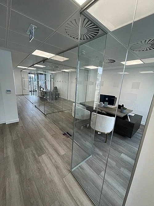 Frameless glass office partition system using clear toughened glass with applied privacy manifestations