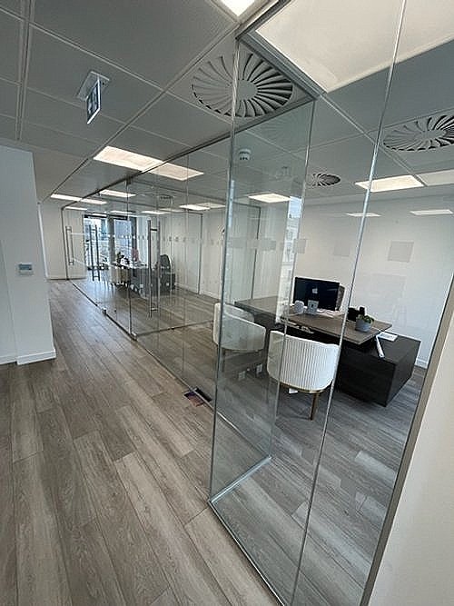 Glass partition in an office on Dovehouse Street, providing a modern, open design while dividing workspaces.