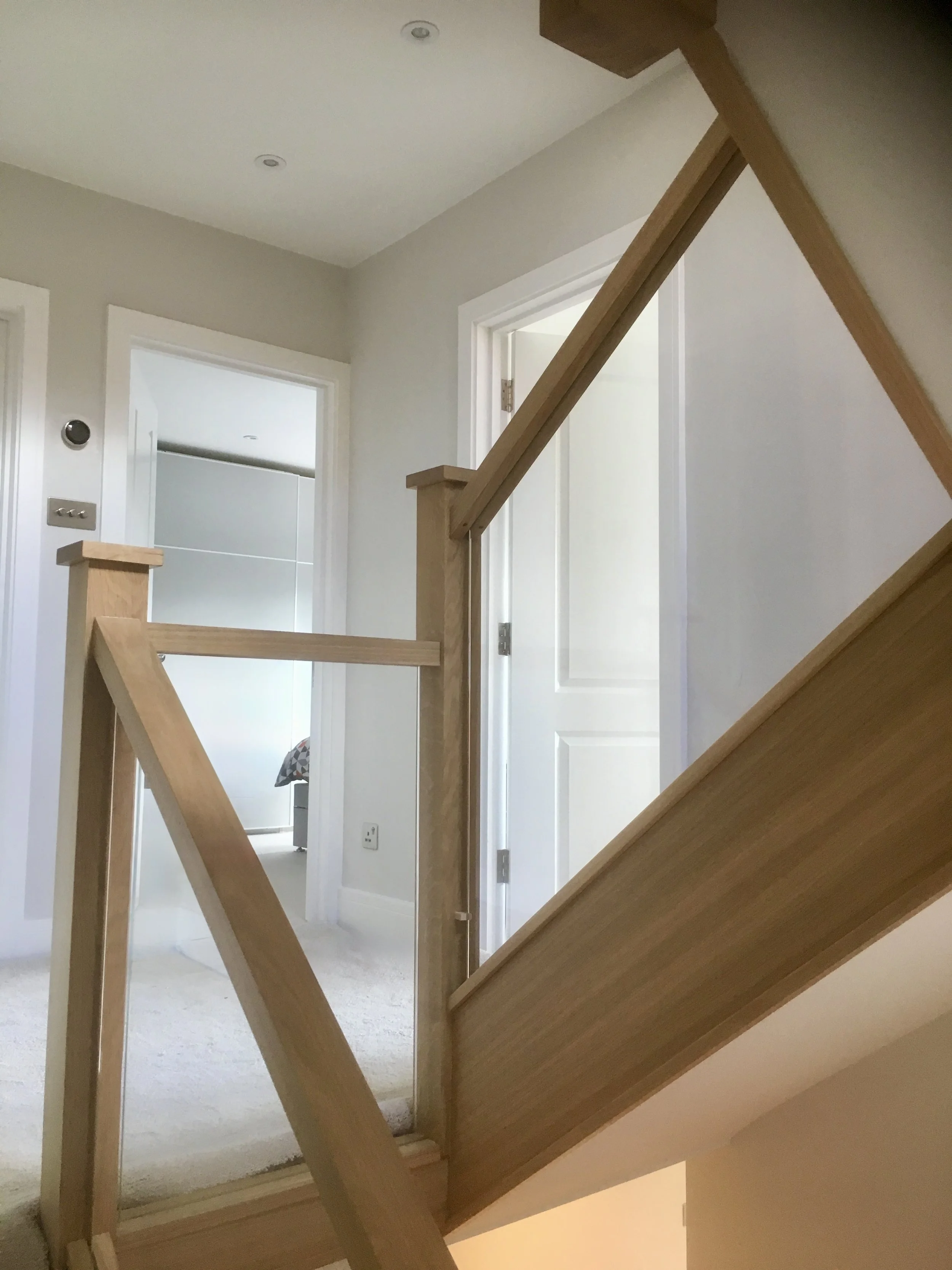 Infill shuffle-glazed toughened glass balustrade panels set within concealed void for seamless installation