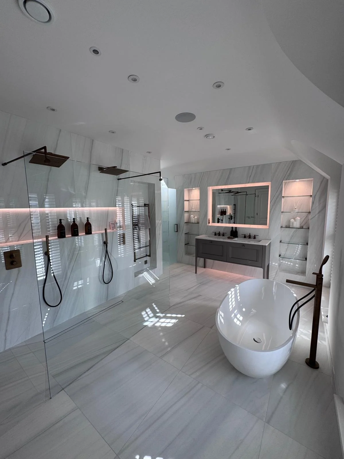 Frameless glass shower screen cleaned with microfiber cloth in luxury bathroom