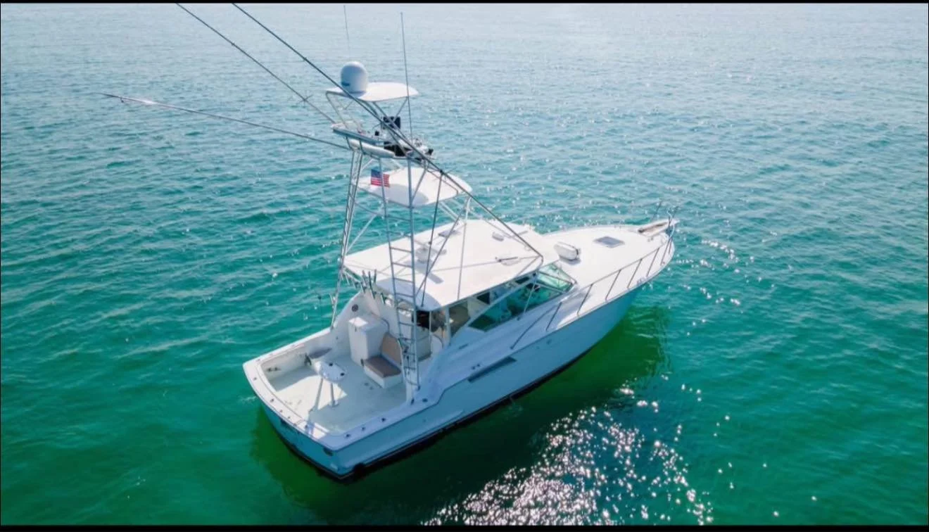 A white motor yacht with a tower and radar equipment sailing on the ocean