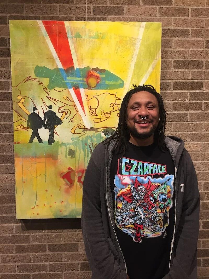 Mike Graves in front of his piece “Two Businessman” in the Harrison Center Speck Gallery.