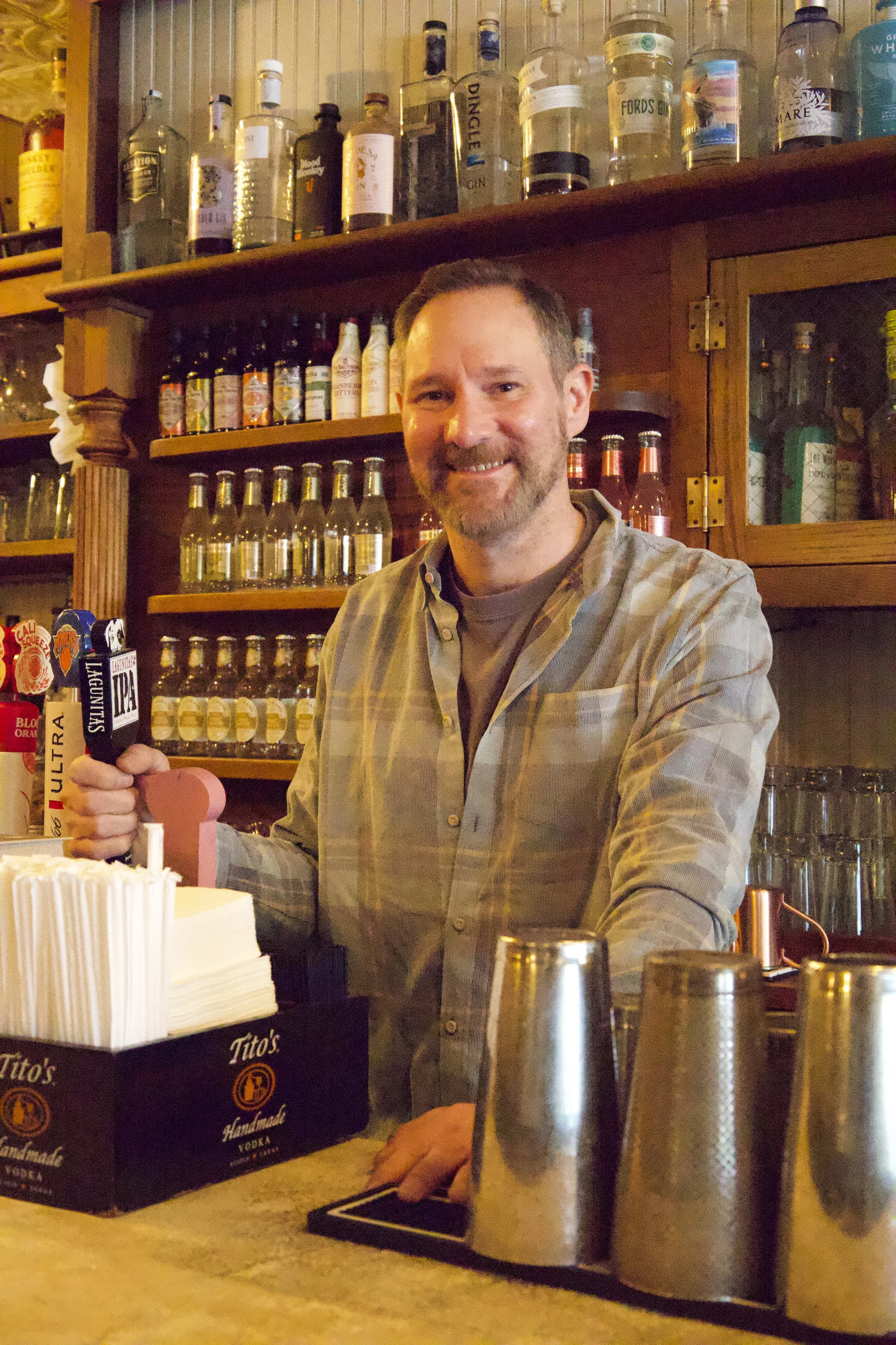 Mark Tafoya, the co-founder of The Winslow, stands behind the bar