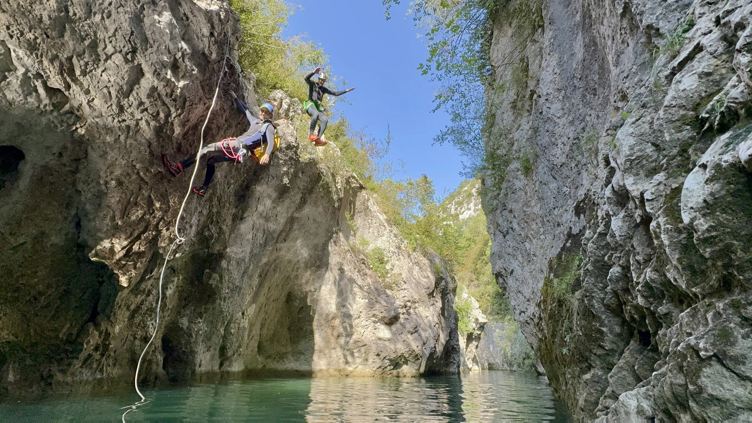 Une personne désecalade et une autre saute dans un canyoning, une expérience inoubliable dans les Gorges du Verdon. Entre rivières cristallines, passages rocheux et moments de détente, l’aventure est au rendez-vous.