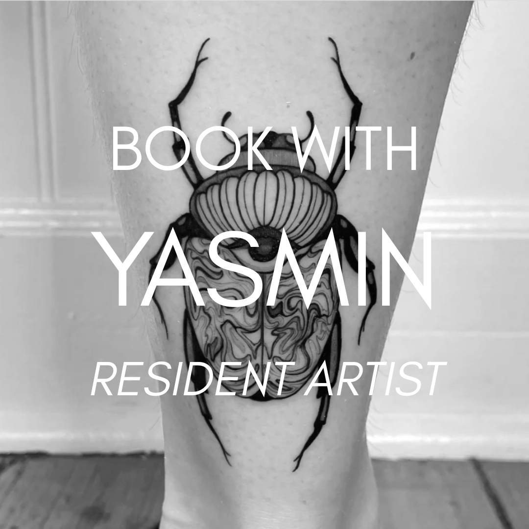 A black and gray tattoo of a crab on a person's arm.