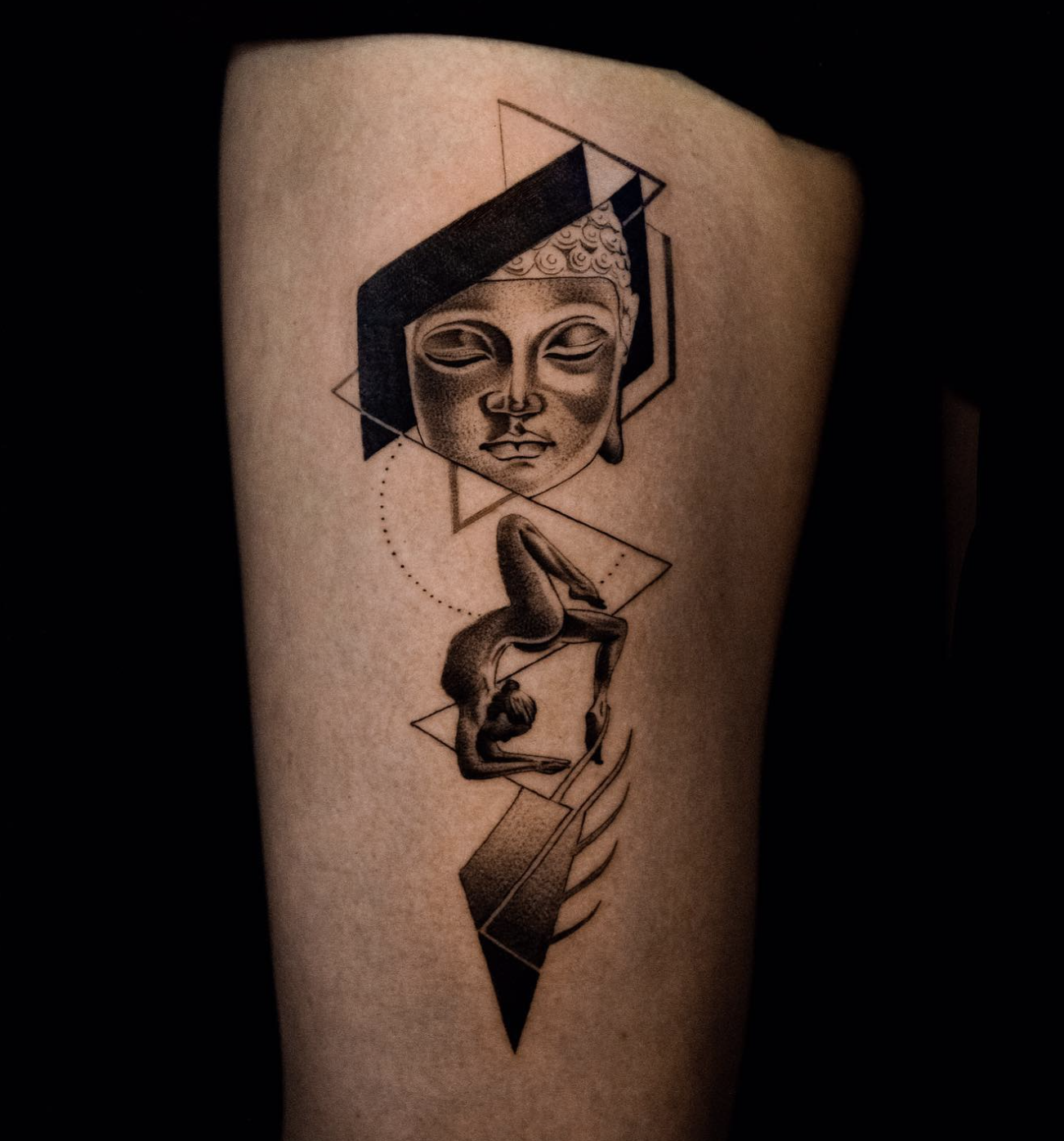 Tattoo of a woman's face with closed eyes, geometric shapes, and a person performing a backbend yoga pose below, all in black ink.