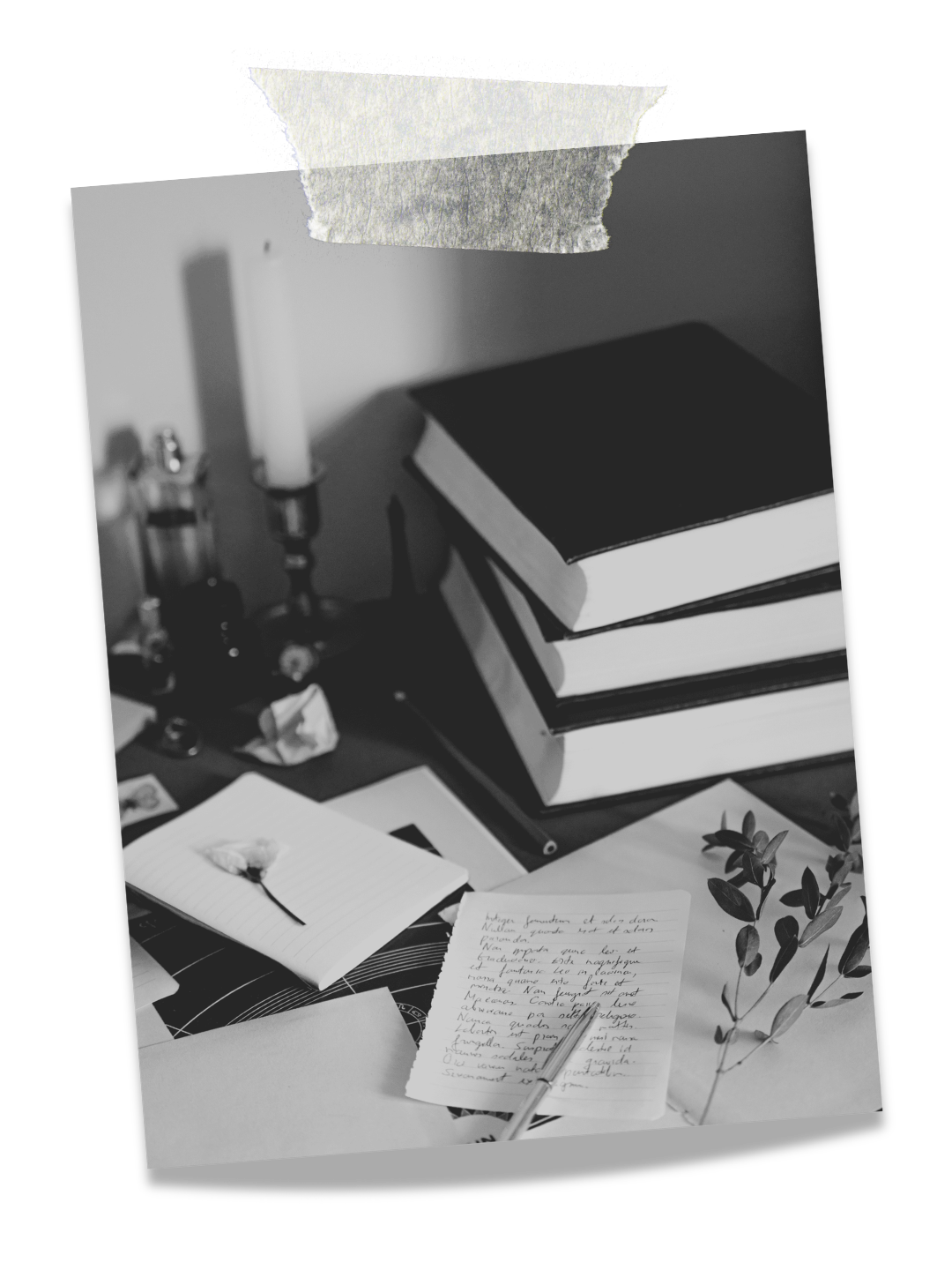 Desk with stacked books, handwritten notes, an open notebook with a flower drawing, and a potted plant.