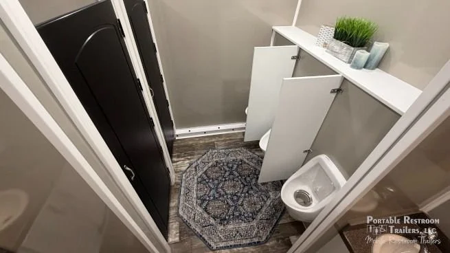 Women's restroom interior with private flushing toilet stalls and sinks in a 10-stall luxury restroom trailer