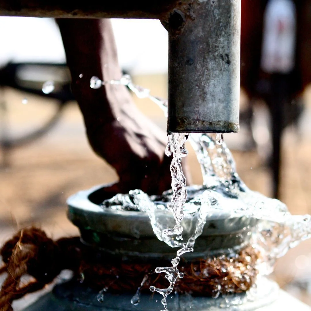 Close-up of clean water from a pump, illustrating how William David Homes supports partner charities.